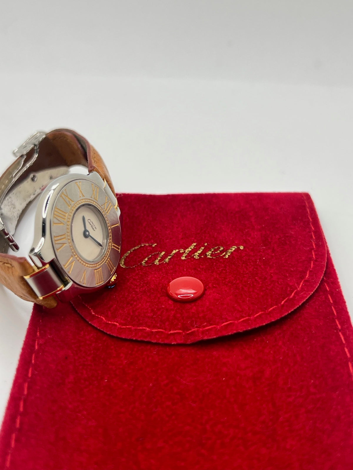 Montre Cartier 21 Must de Cartier 9011 pour femme, équipée d’un mouvement quartz et d’un boîtier en acier de 28 mm. Son cadran blanc offre une esthétique élégante et intemporelle. Cette montre Cartier est montée sur un bracelet brun en cuir avec boucle déployante à plis. En bon état, elle présente des traces d’usure visibles et perceptibles, notamment quelques rayures, éraflures et petites bosses. Révisée en interne en septembre 2026.
