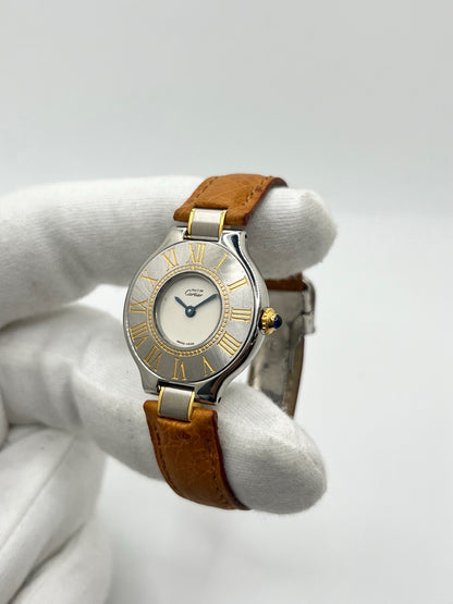 Montre Cartier 21 Must de Cartier 9011 pour femme, équipée d’un mouvement quartz et d’un boîtier en acier de 28 mm. Son cadran blanc offre une esthétique élégante et intemporelle. Cette montre Cartier est montée sur un bracelet brun en cuir avec boucle déployante à plis. En bon état, elle présente des traces d’usure visibles et perceptibles, notamment quelques rayures, éraflures et petites bosses. Révisée en interne en septembre 2026.
