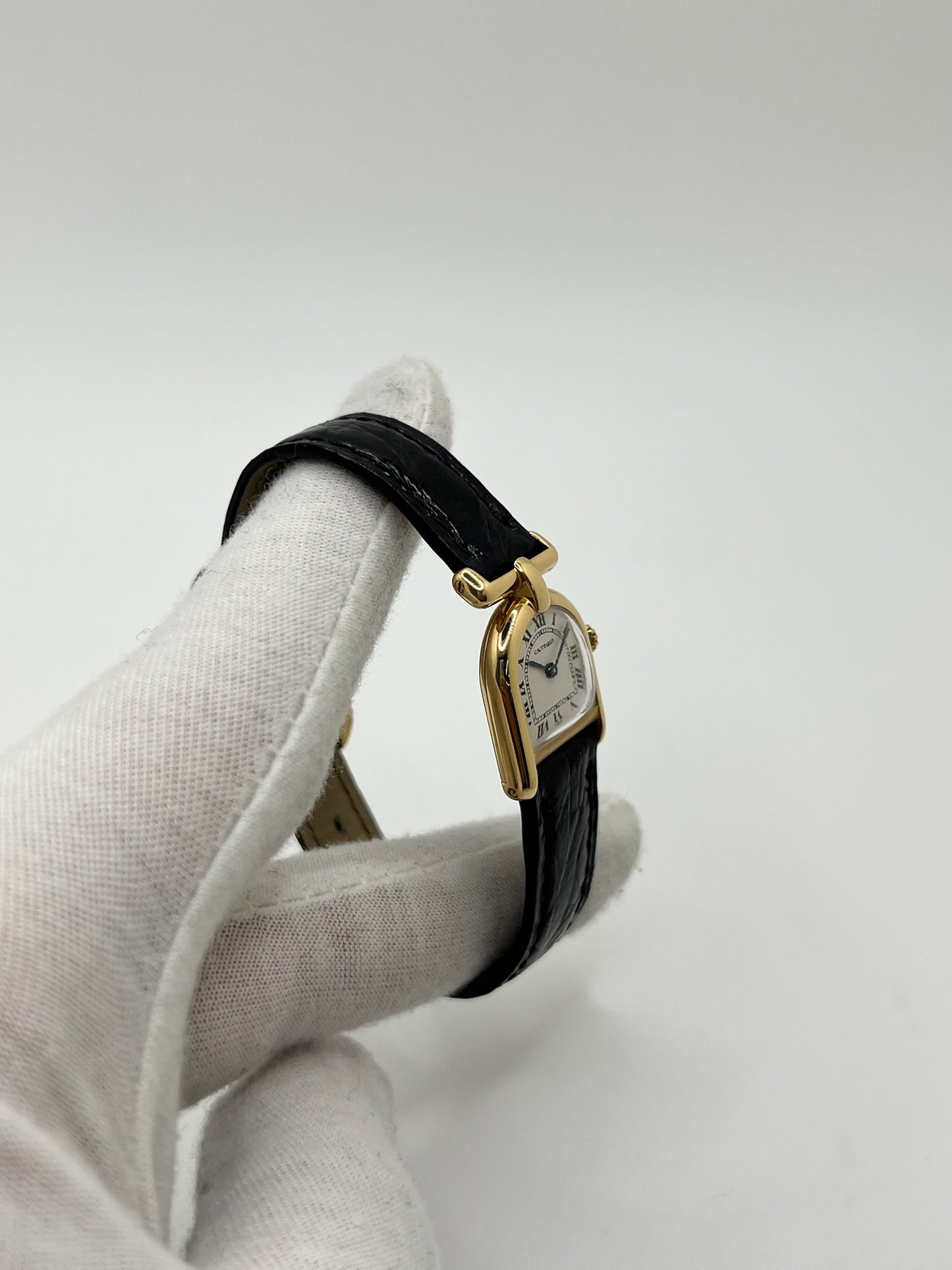 Montre Cartier modèle Calandre pour femme élégante en or jaune avec boîtier rectangulaire de 18 x 26 mm, lignes raffinées et design iconique des années 1980. Cadran blanc lumineux orné de chiffres romains noirs, protégé par un verre minéral. Mouvement à quartz assurant une lecture précise de l’heure. Bracelet en cuir de crocodile noir apportant une touche sophistiquée, équipé d’une boucle ardillon en acier. Modèle vintage en très bon état, présentant de légères micro-rayures superficielles liées à l’âge.