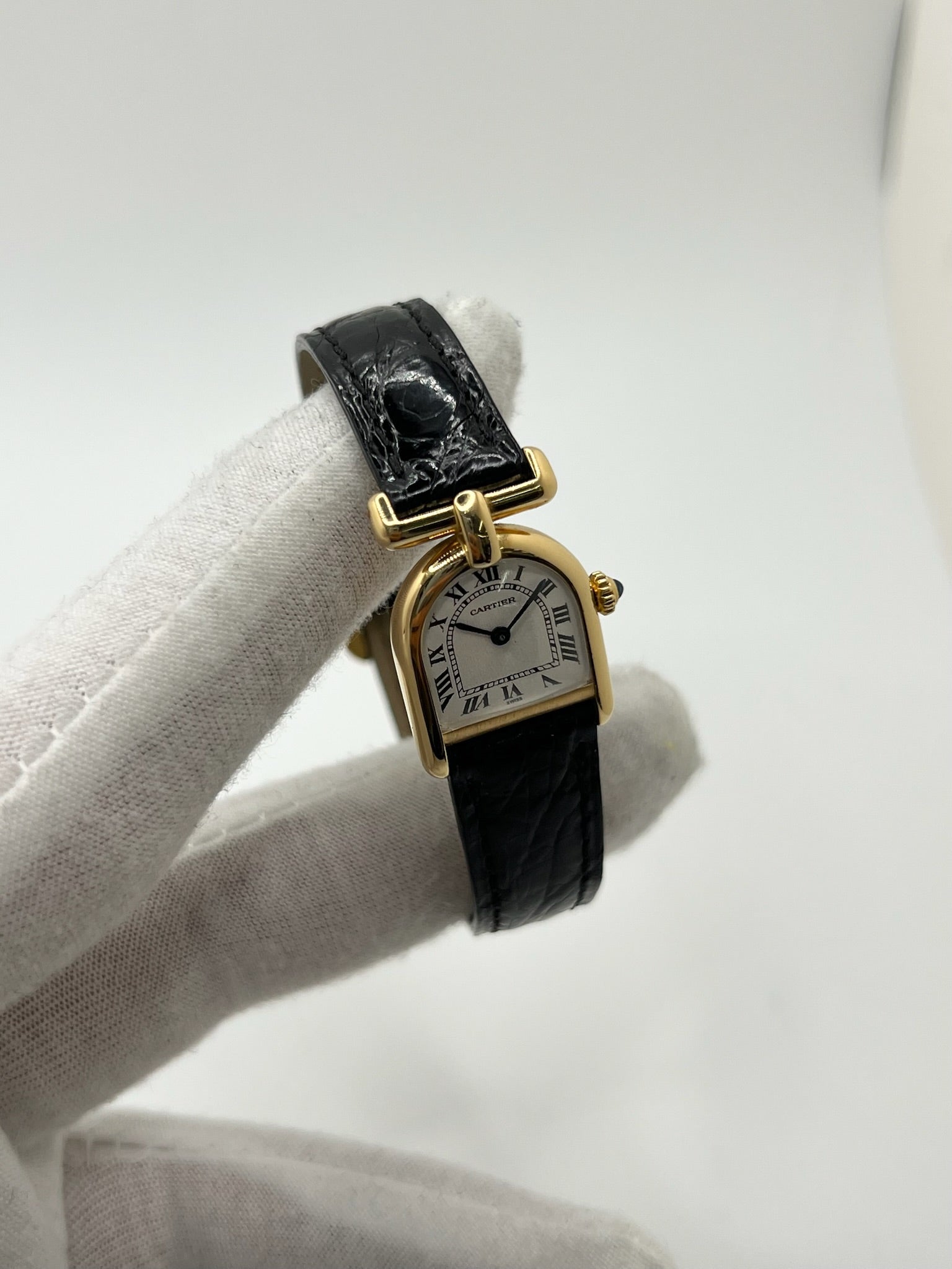 Montre Cartier modèle Calandre pour femme élégante en or jaune avec boîtier rectangulaire de 18 x 26 mm, lignes raffinées et design iconique des années 1980. Cadran blanc lumineux orné de chiffres romains noirs, protégé par un verre minéral. Mouvement à quartz assurant une lecture précise de l’heure. Bracelet en cuir de crocodile noir apportant une touche sophistiquée, équipé d’une boucle ardillon en acier. Modèle vintage en très bon état, présentant de légères micro-rayures superficielles liées à l’âge.