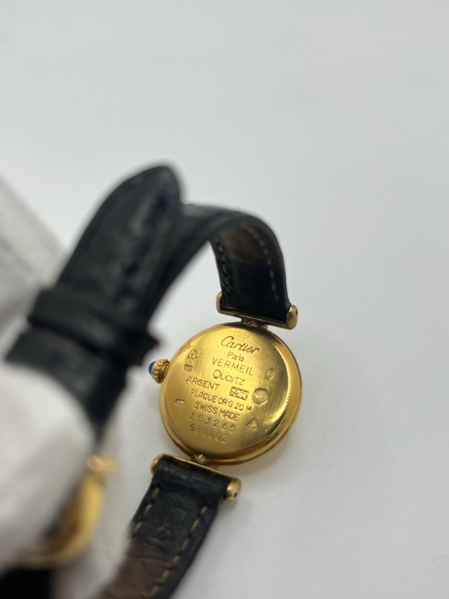 Montre Cartier Colisée Must Vermeil réf. 590002 pour femme, équipée d’un mouvement quartz précis. Boîtier en argent vermeil de 24 mm, cadran blanc à chiffres romains, verre saphir et bracelet en cuir noir avec boucle ardillon. Modèle d’occasion en bon état présentant quelques traces d’usure. Idéal pour les amateurs de montres élégantes et intemporelles.