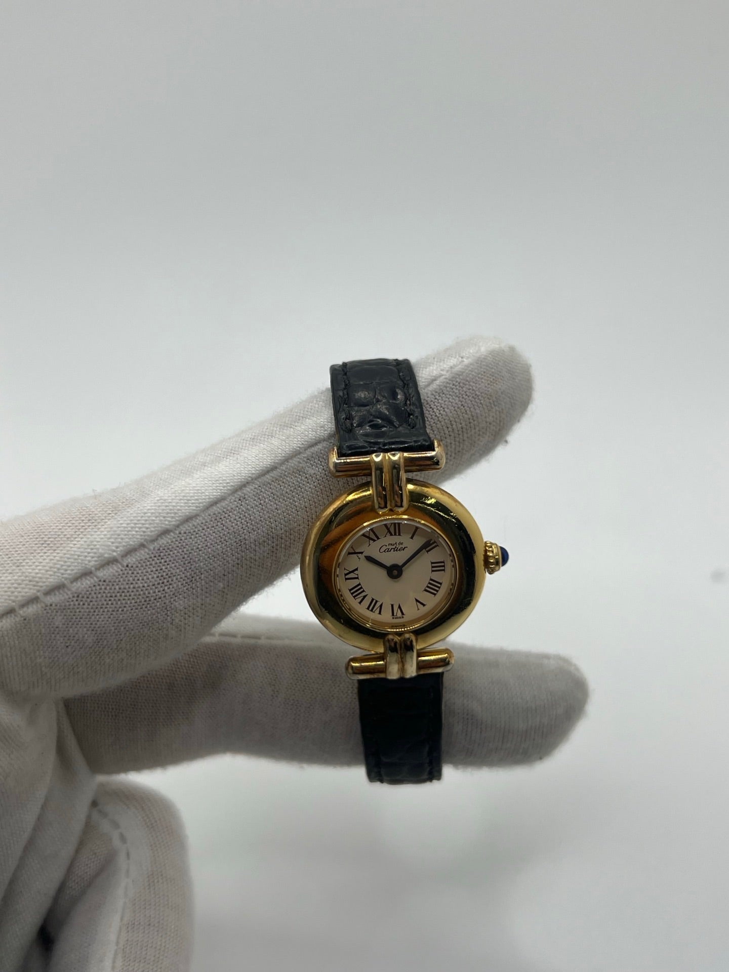 Montre Cartier Colisée Must Vermeil réf. 590002 pour femme, équipée d’un mouvement quartz précis. Boîtier en argent vermeil de 24 mm, cadran blanc à chiffres romains, verre saphir et bracelet en cuir noir avec boucle ardillon. Modèle d’occasion en bon état présentant quelques traces d’usure. Idéal pour les amateurs de montres élégantes et intemporelles.