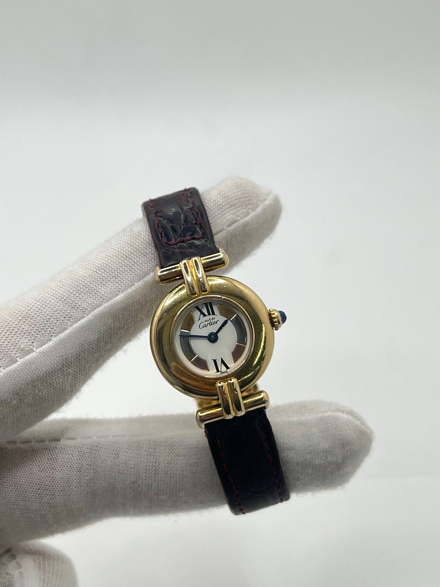 Montre femme Cartier Colisée réf. 590002 en argent avec mouvement quartz. Modèle vintage de 1995 au cadran blanc à chiffres romains et bracelet en cuir or. Verre saphir, boucle ardillon en argent. Élégance intemporelle signée Cartier, livrée avec coffret et papiers d’origine. Montre d’occasion en bon état, révisée en 2025.