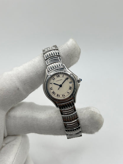Montre Cartier Cougar référence 1215 1 en acier inoxydable avec boîtier de 26 mm et bracelet assorti. Ce modèle à mouvement quartz se distingue par son cadran blanc à chiffres romains, son verre saphir résistant aux rayures et son affichage de la date. Son design emblématique allie élégance et sobriété, caractéristique des créations horlogères de la maison Cartier. Montre d'occasion de 1995 en très bon état, révisée, avec coffret et papiers d'origine.
