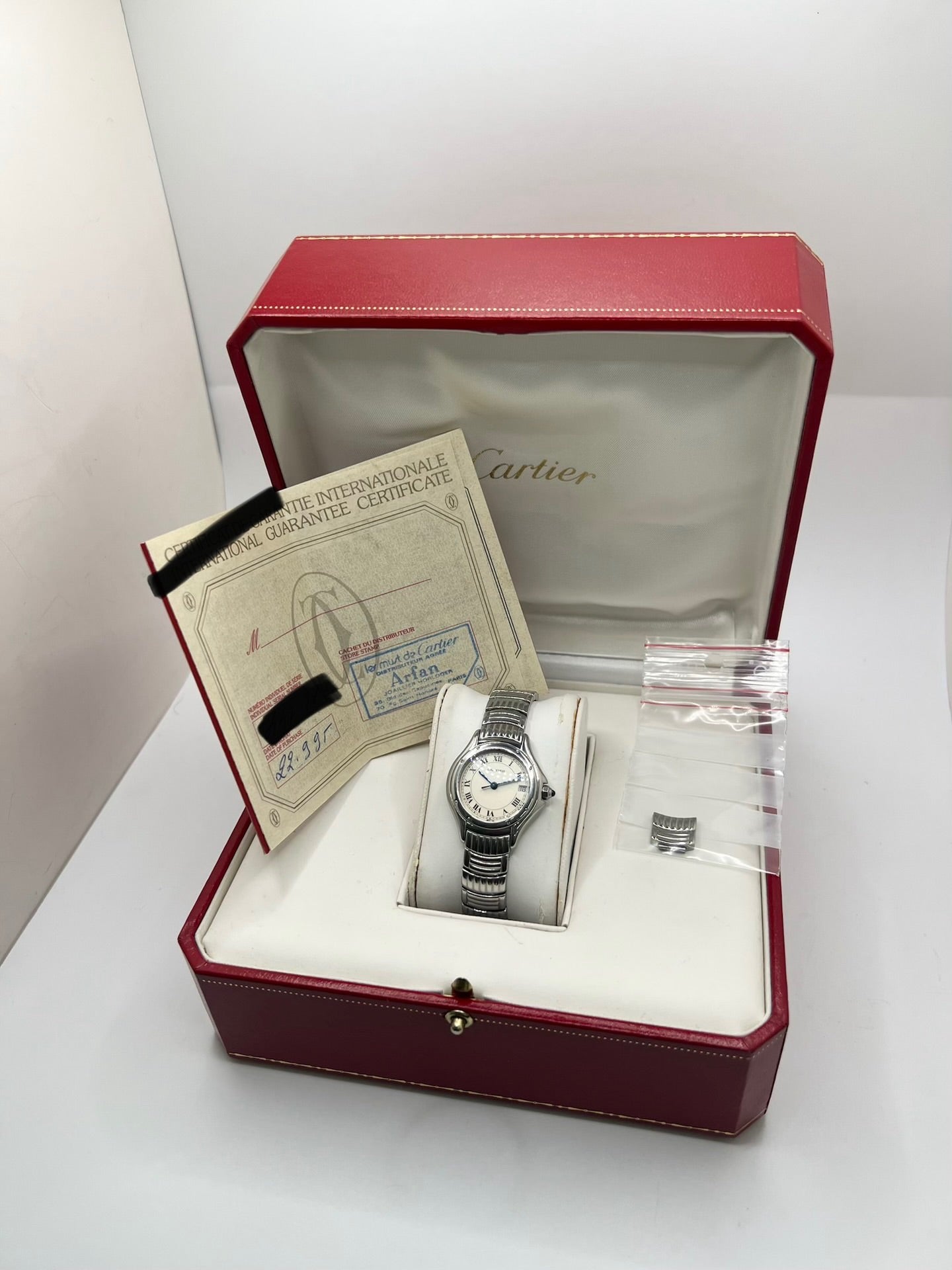 Montre Cartier Cougar référence 1215 1 en acier inoxydable avec boîtier de 26 mm et bracelet assorti. Ce modèle à mouvement quartz se distingue par son cadran blanc à chiffres romains, son verre saphir résistant aux rayures et son affichage de la date. Son design emblématique allie élégance et sobriété, caractéristique des créations horlogères de la maison Cartier. Montre d'occasion de 1995 en très bon état, révisée, avec coffret et papiers d'origine.
