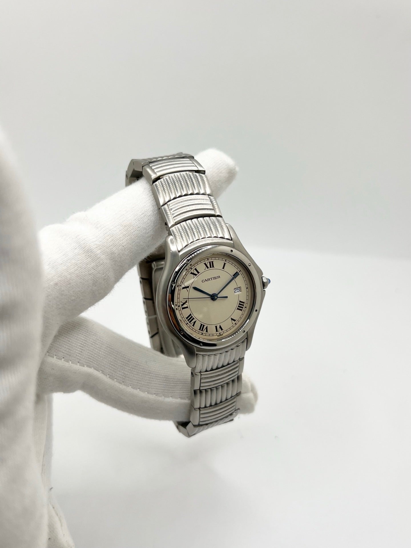 Montre Cartier Cougar référence 120000R en acier, équipée d'un mouvement quartz et fabriquée en 1998. Son boîtier de 33 mm est associé à un élégant cadran blanc à chiffres romains, protégé par un verre saphir résistant aux rayures. Cette montre Cartier Cougar dispose d'un bracelet en acier avec boucle déployante et d'une fonction date. Vendue avec son coffret d'origine, elle est en très bon état, révisée en interne et idéale pour un usage homme ou unisexe.