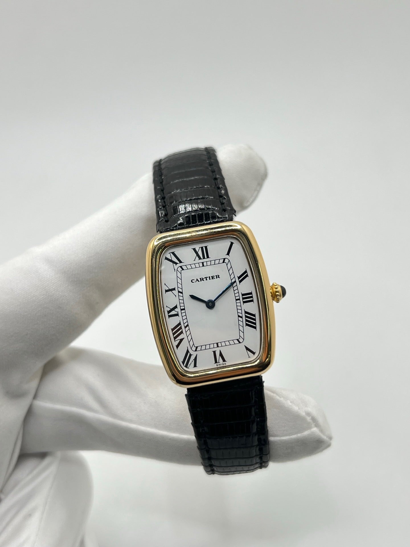 Montre Cartier Fabergé vintage en or jaune avec boîtier rectangulaire de 26 mm, cadran blanc à chiffres romains et bracelet en cuir noir. Ce modèle élégant à remontage manuel, fabriqué vers 1970, séduit par son style intemporel et raffiné. Montre homme ou unisexe d’occasion en très bon état, livrée avec coffret d’origine, idéale pour les amateurs d’horlogerie de luxe et de pièces vintage authentiques.