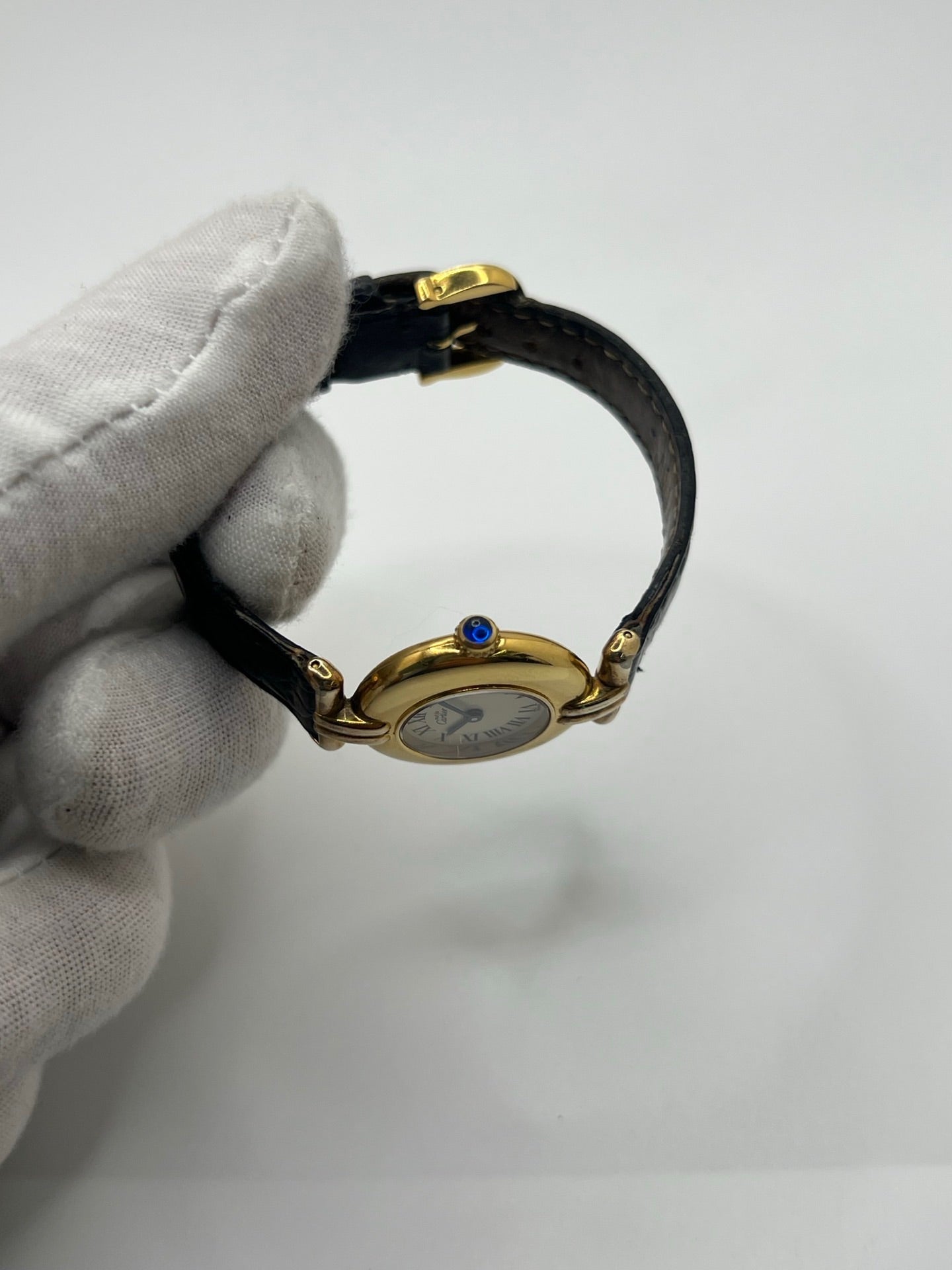 Montre Cartier Colisée Must Vermeil réf. 590002 pour femme, équipée d’un mouvement quartz précis. Boîtier en argent vermeil de 24 mm, cadran blanc à chiffres romains, verre saphir et bracelet en cuir noir avec boucle ardillon. Modèle d’occasion en bon état présentant quelques traces d’usure. Idéal pour les amateurs de montres élégantes et intemporelles.