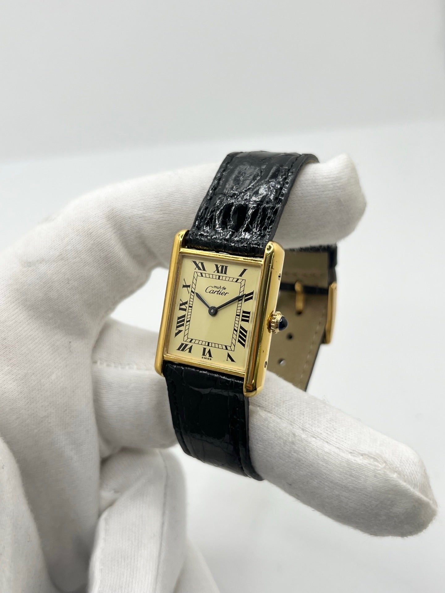 Montre Cartier Tank Vermeil mécanique vintage en argent plaqué or, dotée d’un mouvement à remontage manuel. Ce modèle emblématique présente un cadran champagne à chiffres romains, un boîtier rectangulaire de 23 x 30 mm et un bracelet en cuir de crocodile noir avec boucle ardillon en acier. Élégante et intemporelle, cette montre Cartier Must Tank d’occasion en très bon état séduit les amateurs d’horlogerie classique et de montres de luxe vintage.
