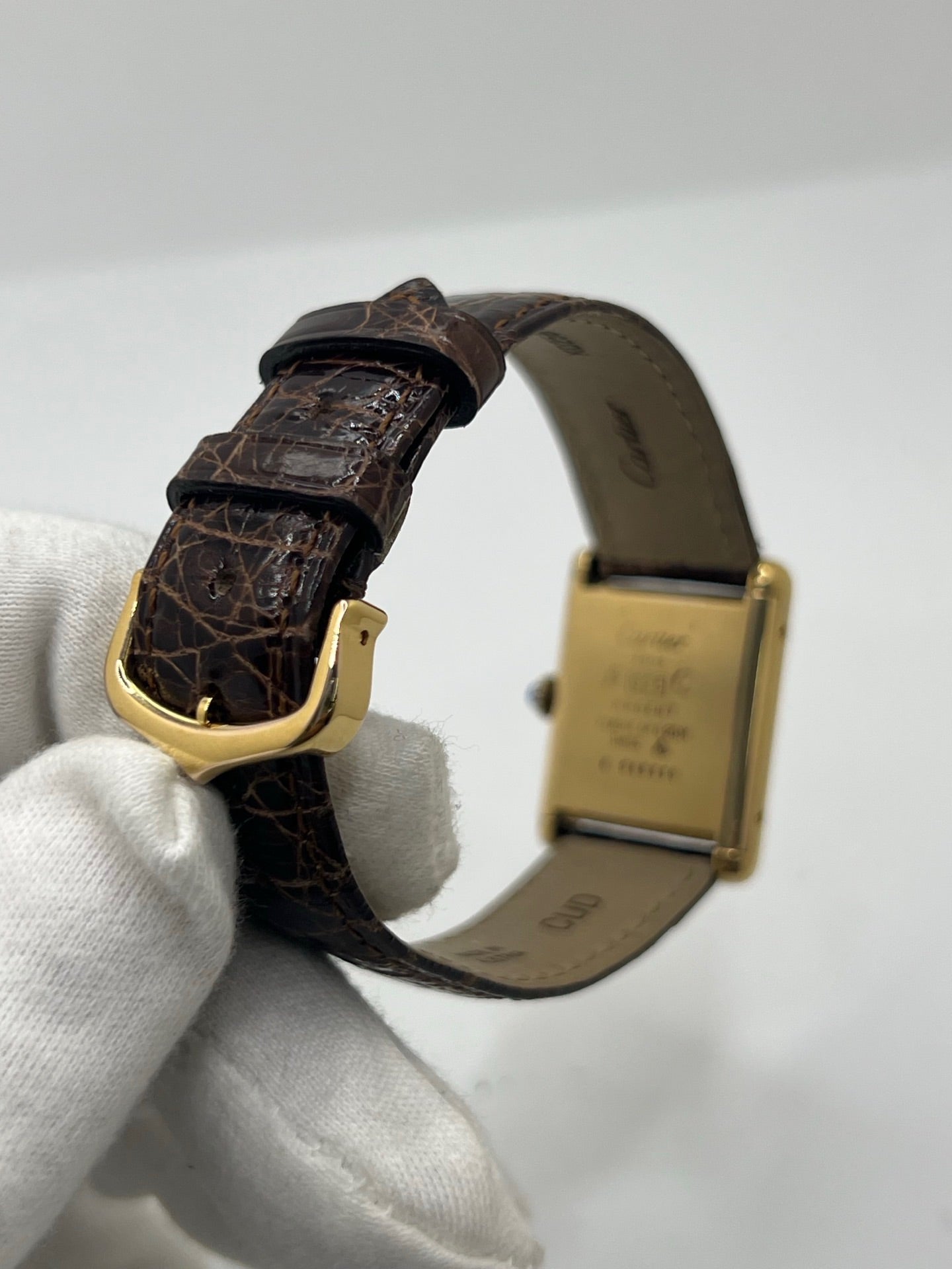 Montre Cartier Tank Must Vermeil Œil de Tigre vintage avec boîtier rectangulaire en vermeil, mouvement à remontage manuel et cadran en pierre naturelle œil de tigre aux reflets bruns et dorés. Cette Cartier Must Tank Vermeil se distingue par son design emblématique, son bracelet en cuir brun et son élégance intemporelle. Montre de collection recherchée par les amateurs de montres Cartier vintage, alliant raffinement, caractère et savoir-faire horloger.