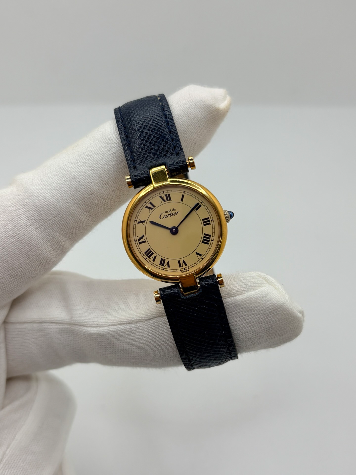 Montre Cartier Must Vendôme PM pour femme, équipée d’un mouvement à quartz et présentée dans un boîtier en argent de 24 mm. Son cadran blanc à chiffres romains est protégé par un verre saphir. Cette montre Cartier est montée sur un bracelet en cuir bleu avec boucle ardillon en acier. Élégante et intemporelle, la Cartier Must Vendôme PM séduit par son format compact, son design raffiné et son style emblématique, idéale au quotidien ou pour une occasion spéciale.