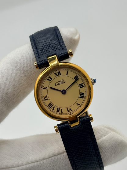 Montre Cartier Must Vendôme PM pour femme, équipée d’un mouvement à quartz et présentée dans un boîtier en argent de 24 mm. Son cadran blanc à chiffres romains est protégé par un verre saphir. Cette montre Cartier est montée sur un bracelet en cuir bleu avec boucle ardillon en acier. Élégante et intemporelle, la Cartier Must Vendôme PM séduit par son format compact, son design raffiné et son style emblématique, idéale au quotidien ou pour une occasion spéciale.