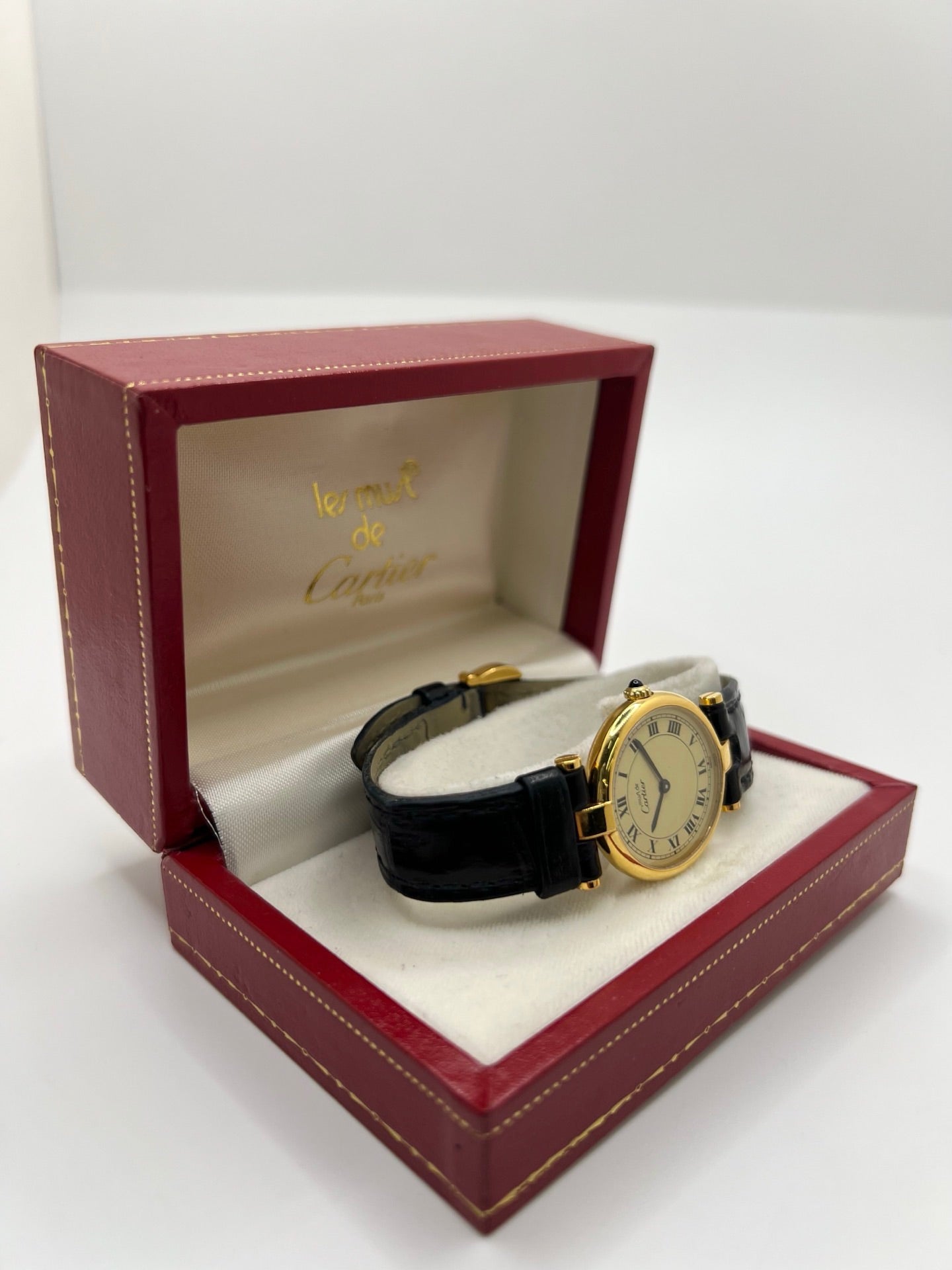 Montre Cartier Must Vendôme en vermeil, boîtier en argent plaqué or au diamètre de 30 mm, accompagnée d’un cadran blanc à chiffres romains signature. Équipée d’un mouvement quartz précis et d’un bracelet en cuir noir avec boucle en acier. Modèle élégant et intemporel, idéal pour un poignet féminin. Montre d’occasion en très bon état, présentant de légères micro-rayures, révisée en interne, livrée avec son coffret d’origine.