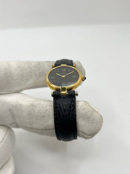 Cartier Must Vendôme référence 590004 en argent avec boîtier de 24 mm, cadran noir à chiffres romains et mouvement à quartz. Cette montre femme est équipée d'un bracelet en cuir, d'une boucle ardillon en acier et d'un verre saphir. Modèle d'occasion en très bon état, révisé en interne en 2026. Une montre Cartier vintage au design élégant, idéale pour les amateurs d'horlogerie de luxe et de pièces intemporelles.
