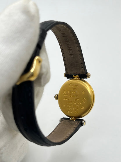Cartier Must Vendôme référence 590004 en argent avec boîtier de 24 mm, cadran noir à chiffres romains et mouvement à quartz. Cette montre femme est équipée d'un bracelet en cuir, d'une boucle ardillon en acier et d'un verre saphir. Modèle d'occasion en très bon état, révisé en interne en 2026. Une montre Cartier vintage au design élégant, idéale pour les amateurs d'horlogerie de luxe et de pièces intemporelles.
