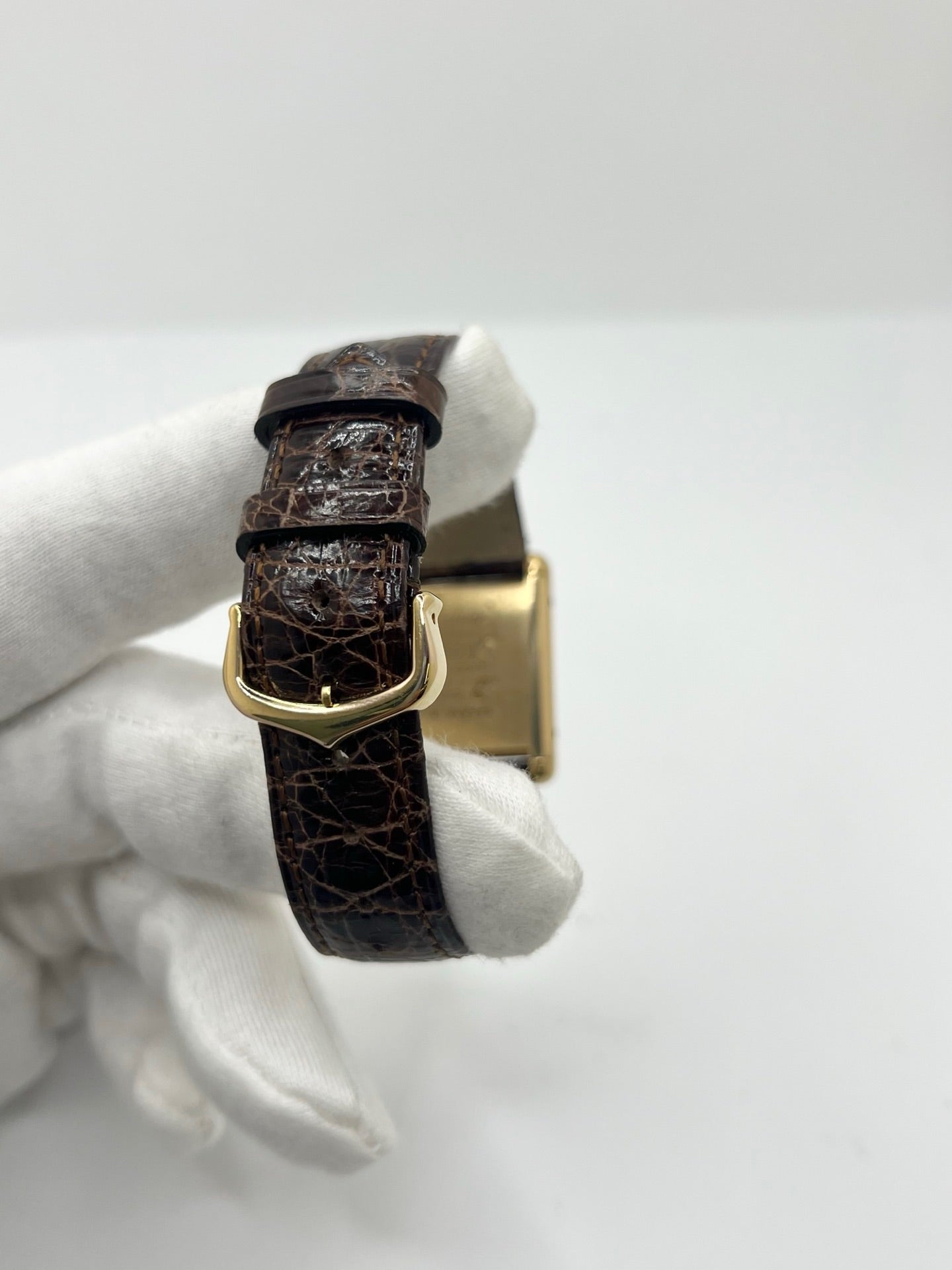 Montre Cartier Tank Must Vermeil Œil de Tigre vintage avec boîtier rectangulaire en vermeil, mouvement à remontage manuel et cadran en pierre naturelle œil de tigre aux reflets bruns et dorés. Cette Cartier Must Tank Vermeil se distingue par son design emblématique, son bracelet en cuir brun et son élégance intemporelle. Montre de collection recherchée par les amateurs de montres Cartier vintage, alliant raffinement, caractère et savoir-faire horloger.