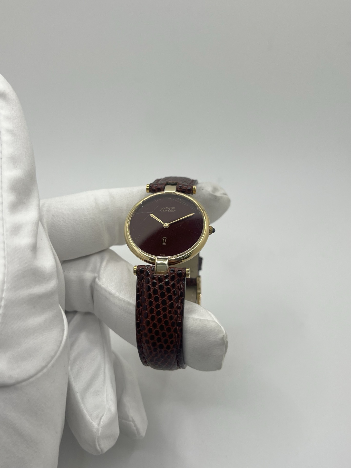 Montre Cartier Must Vendôme Vermeil 30 mm avec cadran bordeaux “burgundy”. Ce modèle vintage emblématique présente un boîtier rond en vermeil (argent plaqué or), un cadran laqué rouge profond signature de la collection Must, des aiguilles dorées élégantes et un design classique intemporel. Montre de luxe suisse recherchée par les collectionneurs, idéale pour les amateurs d’horlogerie vintage et de pièces iconiques au style raffiné.