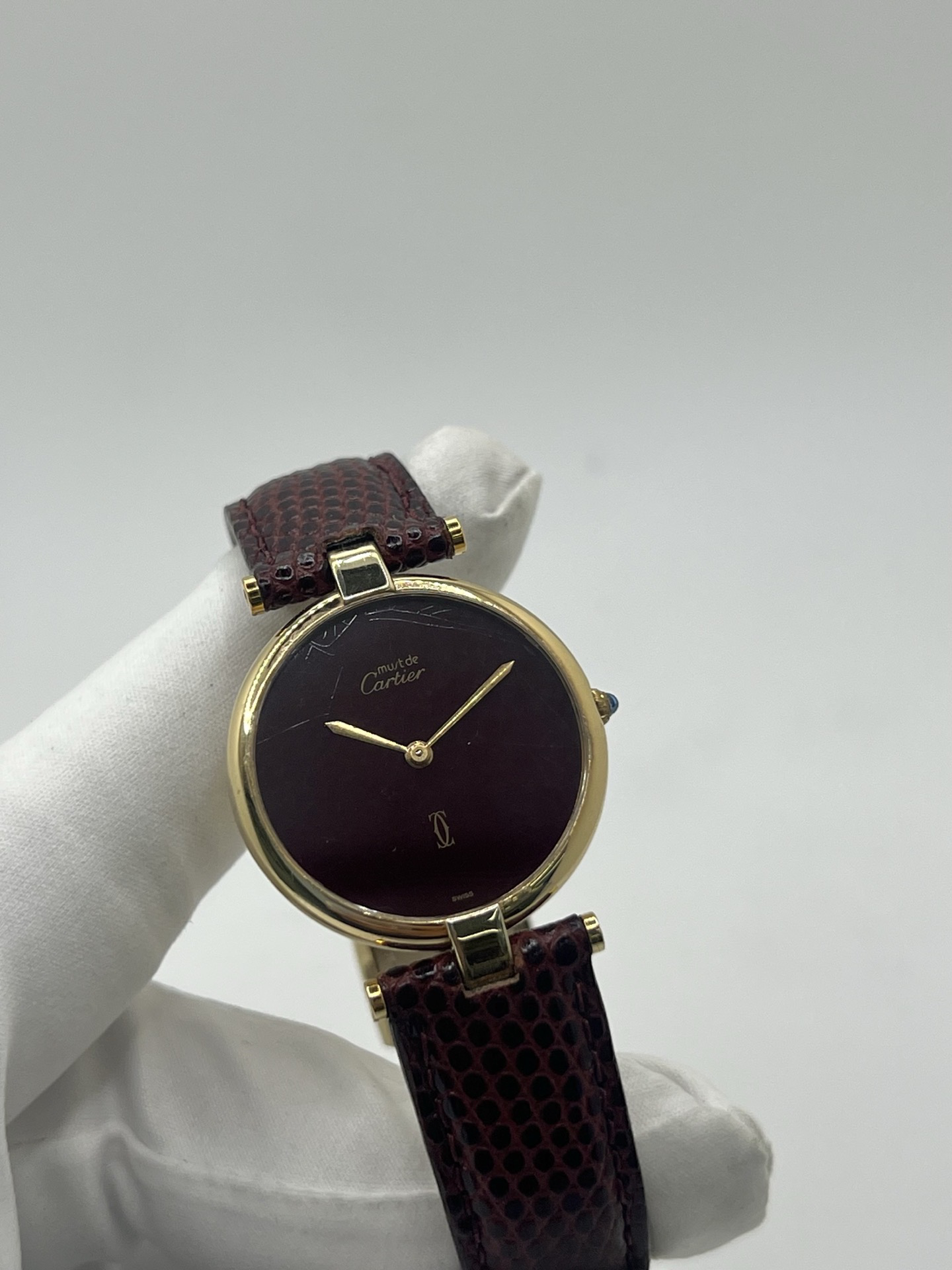 Montre Cartier Must Vendôme Vermeil 30 mm avec cadran bordeaux “burgundy”. Ce modèle vintage emblématique présente un boîtier rond en vermeil (argent plaqué or), un cadran laqué rouge profond signature de la collection Must, des aiguilles dorées élégantes et un design classique intemporel. Montre de luxe suisse recherchée par les collectionneurs, idéale pour les amateurs d’horlogerie vintage et de pièces iconiques au style raffiné.