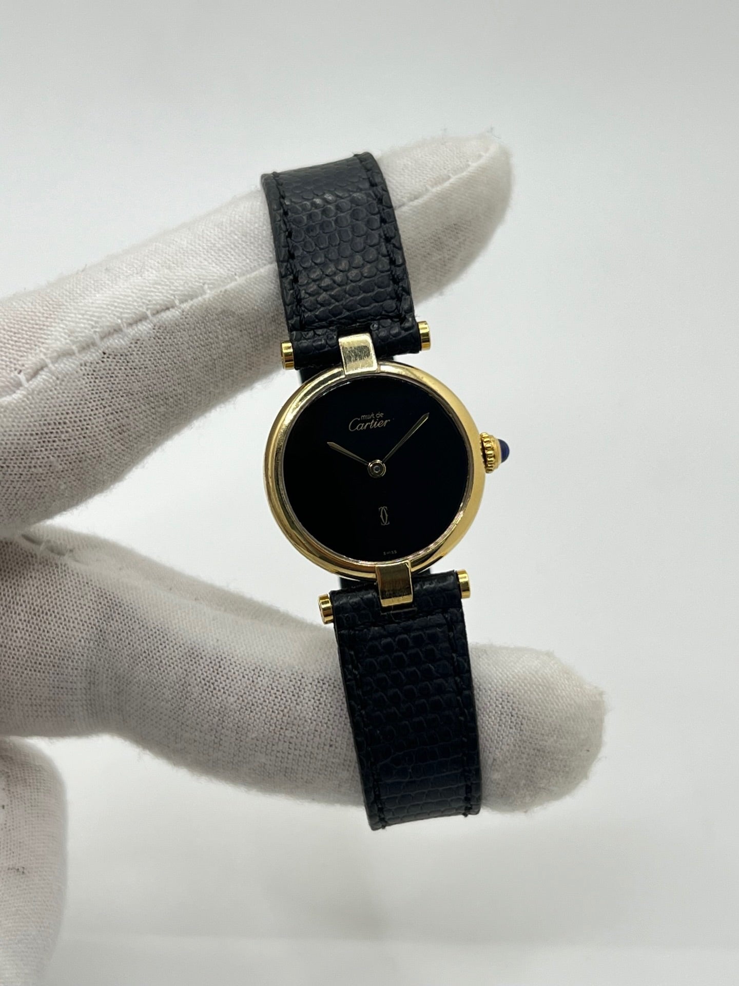 Montre Cartier Must de Cartier Vendome pour femme, boîtier argent de 24 mm avec cadran noir sans chiffres, mouvement quartz précis, verre saphir résistant aux rayures, bracelet cuir noir avec boucle ardillon en acier. État d’occasion très bon, livrée avec coffret d’origine. Élégante et intemporelle, idéale pour collection ou usage quotidien.