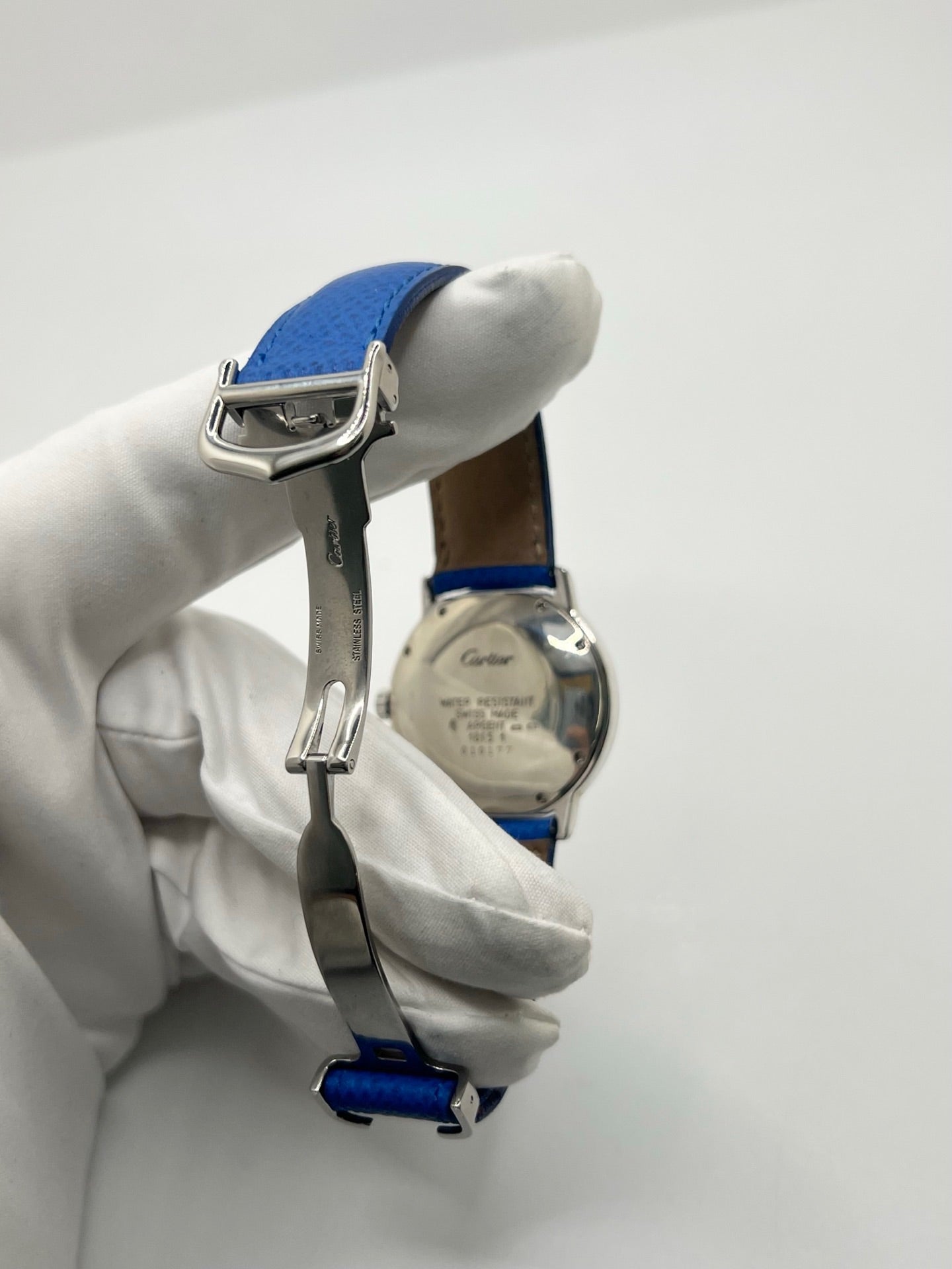 Montre Cartier Must de Cartier Ronde, modèle femme élégant à mouvement quartz. Boîtier rond en métal précieux, cadran blanc raffiné avec chiffres romains, design classique signature Cartier. Bracelet cuir bleu avec boucle ardillon en acier. Verre saphir résistant, diamètre 33 mm. Montre de luxe d’occasion en très bon état, avec légères traces d’usage peu visibles. Révisée en interne le 22 avril 2026. Livrée avec coffret d’origine, sans papiers, disponible à Paris.
