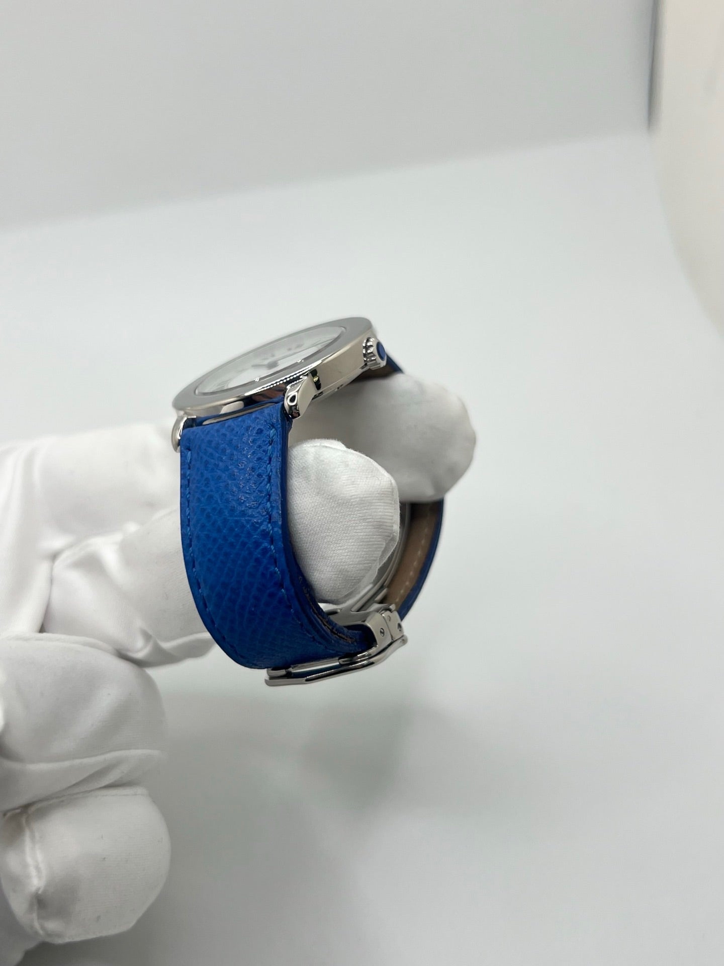 Montre Cartier Must de Cartier Ronde, modèle femme élégant à mouvement quartz. Boîtier rond en métal précieux, cadran blanc raffiné avec chiffres romains, design classique signature Cartier. Bracelet cuir bleu avec boucle ardillon en acier. Verre saphir résistant, diamètre 33 mm. Montre de luxe d’occasion en très bon état, avec légères traces d’usage peu visibles. Révisée en interne le 22 avril 2026. Livrée avec coffret d’origine, sans papiers, disponible à Paris.
