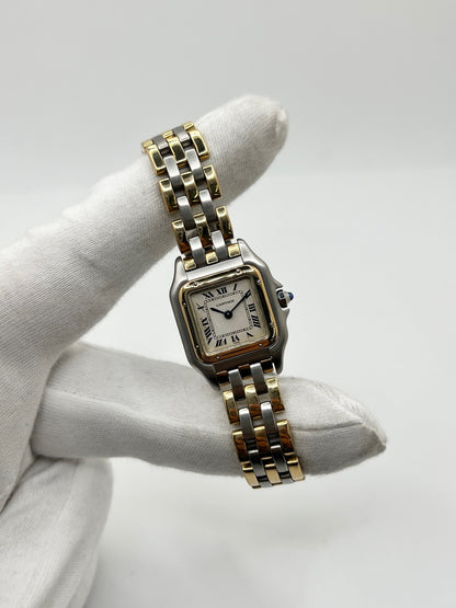 Montre Cartier Panthère 1057917 pour femme, modèle emblématique de la maison Cartier datant de 1989. Cette montre de luxe vintage associe élégamment l’or et l’acier, avec un cadran blanc raffiné, un verre saphir et un mouvement à quartz. La Cartier Panthère référence 1057917 est proposée d’occasion en très bon état, avec son coffret et ses papiers d’origine. Révisée en interne le 19 octobre 2026, cette montre Cartier Panthère en or et acier allie élégance intemporelle et savoir-faire horloger.