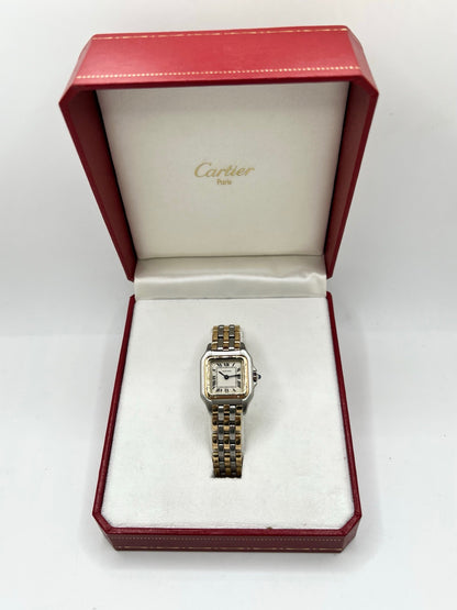 Montre Cartier Panthère 1057917 pour femme, modèle emblématique de la maison Cartier datant de 1989. Cette montre de luxe vintage associe élégamment l’or et l’acier, avec un cadran blanc raffiné, un verre saphir et un mouvement à quartz. La Cartier Panthère référence 1057917 est proposée d’occasion en très bon état, avec son coffret et ses papiers d’origine. Révisée en interne le 19 octobre 2026, cette montre Cartier Panthère en or et acier allie élégance intemporelle et savoir-faire horloger.