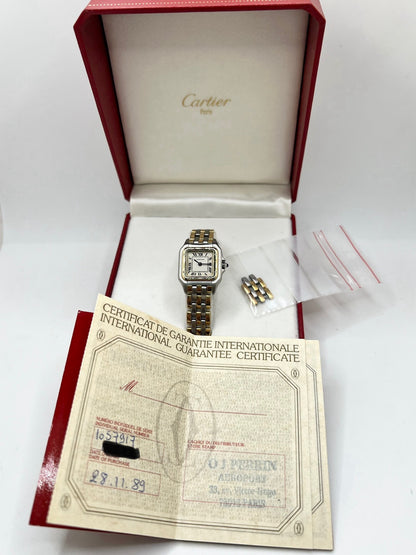 Montre Cartier Panthère 1057917 pour femme, modèle emblématique de la maison Cartier datant de 1989. Cette montre de luxe vintage associe élégamment l’or et l’acier, avec un cadran blanc raffiné, un verre saphir et un mouvement à quartz. La Cartier Panthère référence 1057917 est proposée d’occasion en très bon état, avec son coffret et ses papiers d’origine. Révisée en interne le 19 octobre 2026, cette montre Cartier Panthère en or et acier allie élégance intemporelle et savoir-faire horloger.