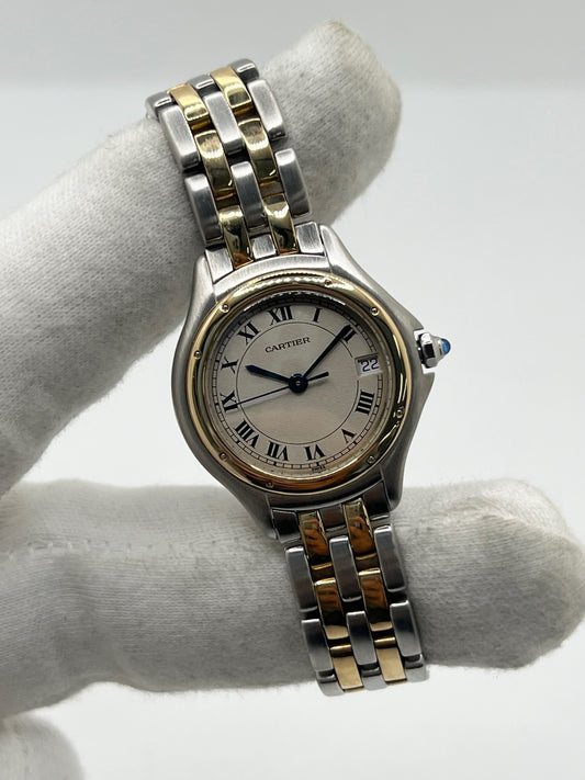 Montre Cartier Panthère référence 119000R pour femme en or jaune et acier, équipée d'un mouvement à quartz. Son boîtier de 26 mm est sublimé par une lunette en or jaune, un cadran blanc à chiffres romains et un verre saphir résistant aux rayures. Son bracelet bicolore en or et acier avec boucle déployante assure un porté confortable. Cette montre d'occasion est en très bon état, révisée en interne et livrée avec son coffret d'origine.