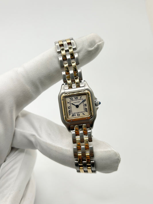 Montre Cartier Panthère 166921 pour femme en or et acier, équipée d’un mouvement quartz suisse. Ce modèle iconique présente un boîtier de 22 x 21 mm, une lunette en or jaune, un cadran blanc à chiffres romains et un verre saphir. Son bracelet en or et acier avec boucle double plis complète son élégance intemporelle. Montre de luxe d’occasion en très bon état, révisée, avec coffret d’origine, idéale pour les amateurs de montres Cartier Panthère femme.