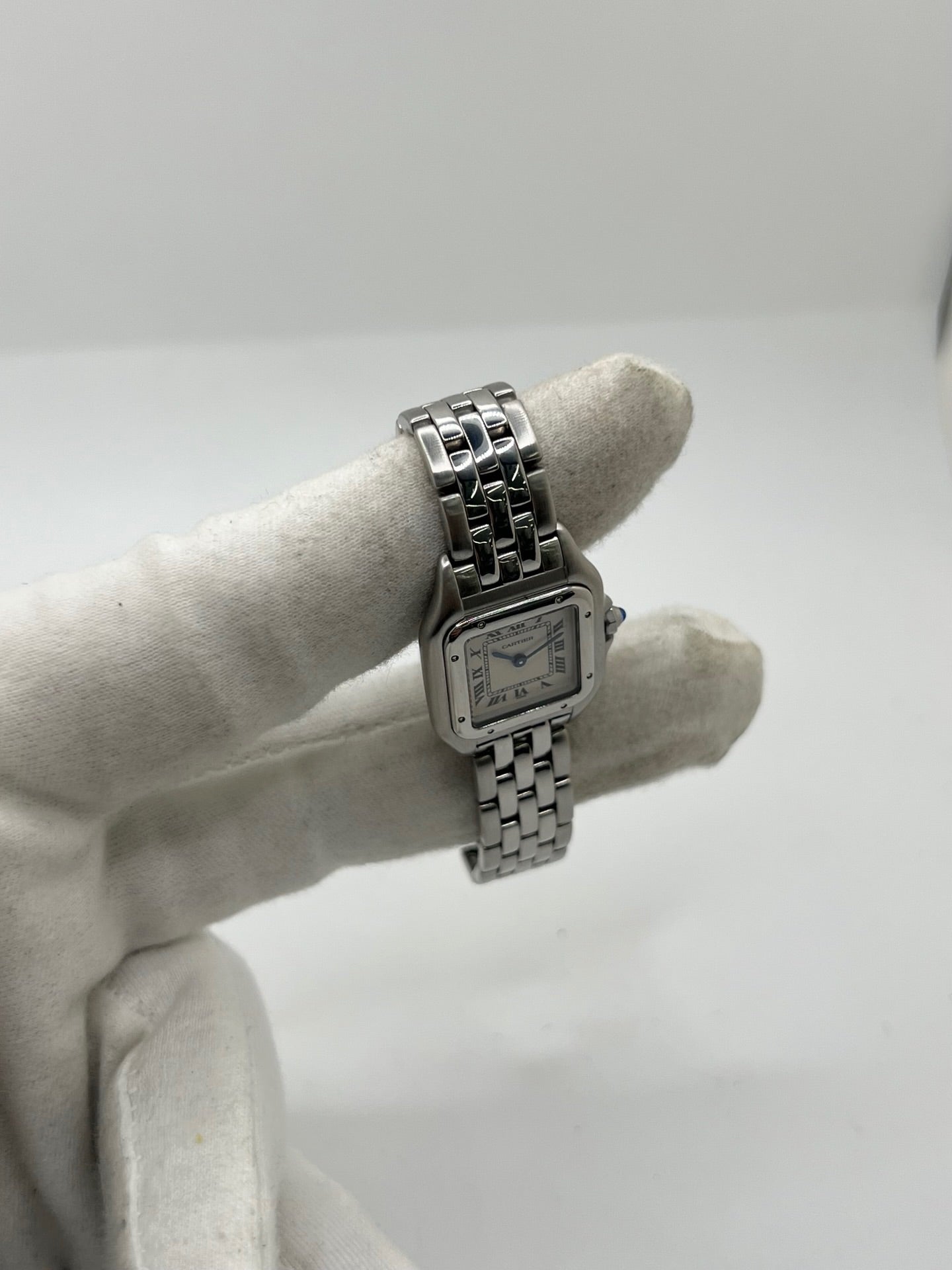Cartier Panthère référence 1320 en acier avec boîtier de 22 mm, cadran blanc à chiffres romains et mouvement à quartz. Cette montre femme est équipée d'un bracelet en acier avec boucle déployante double pli et d'un verre saphir. Modèle d'occasion en très bon état, révisé par le fabricant en 2026, livré avec son coffret et ses papiers d'origine.