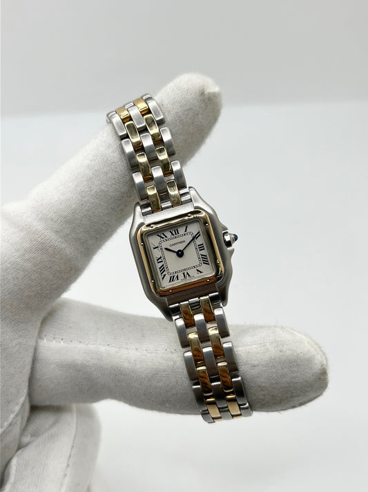 Montre Cartier Panthère référence 66921 pour femme en or jaune et acier, fabriquée en 1985 et équipée d'un mouvement quartz Swiss movement. Son boîtier rectangulaire de 22 x 30 mm est sublimé par une lunette en or jaune, un cadran blanc à chiffres romains et un verre saphir. Cette montre Cartier Panthère bicolore dispose d'un bracelet en or et acier avec boucle déployante. Vendue avec son coffret et ses papiers d'origine, elle est en très bon état et révisée en interne.