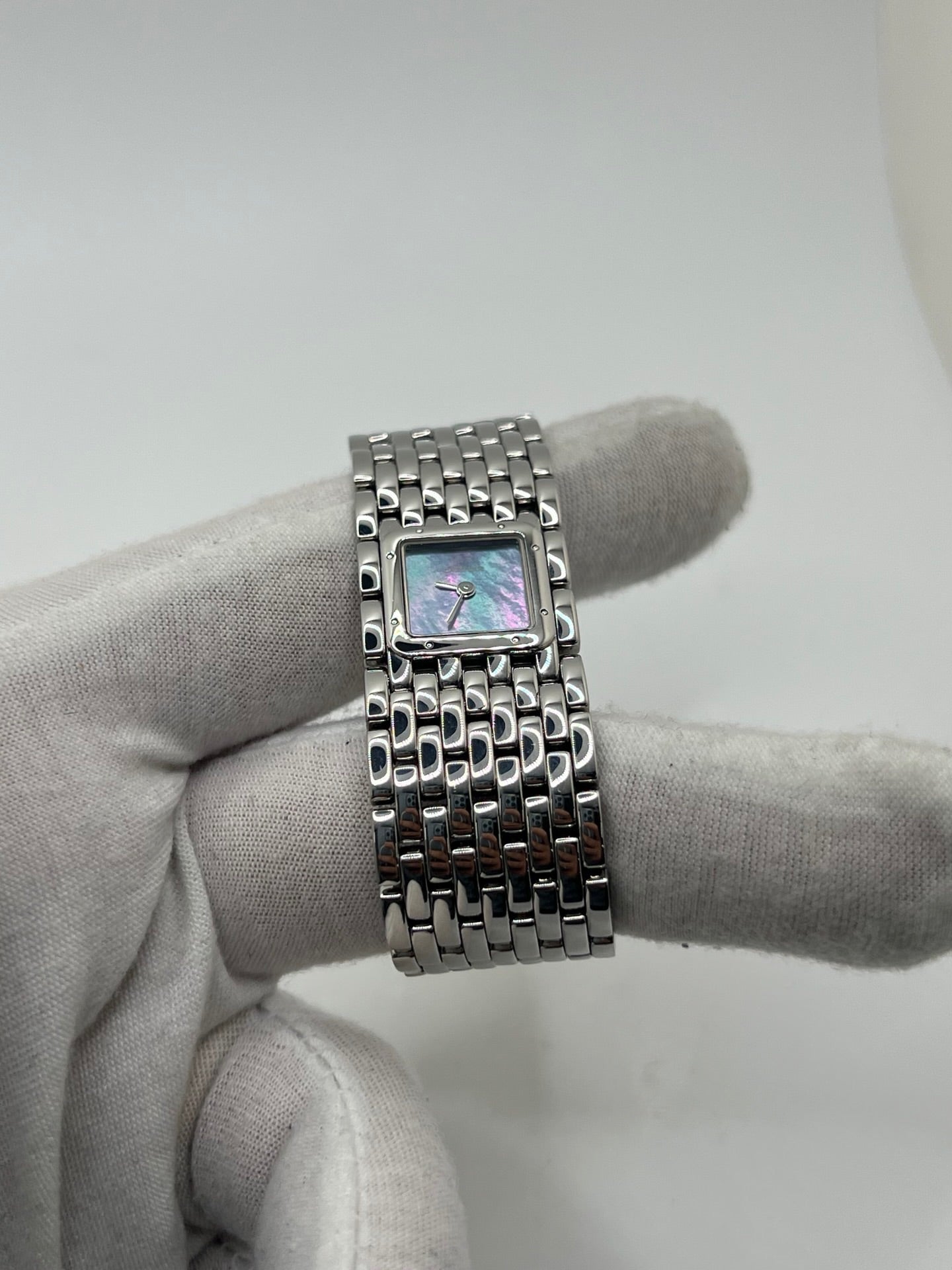 Montre femme de la maison Cartier, modèle Panthère Ruban réf. 2420, en acier avec boîtier de 21 mm et lunette assortie, verre saphir, cadran en nacre aux chiffres romains, mouvement quartz précis, bracelet acier avec boucle double plis. Étanchéité 3 ATM. D’occasion en très bon état, livrée avec coffret d’origine, élégante et intemporelle pour un style raffiné au quotidien ou en occasion spéciale.