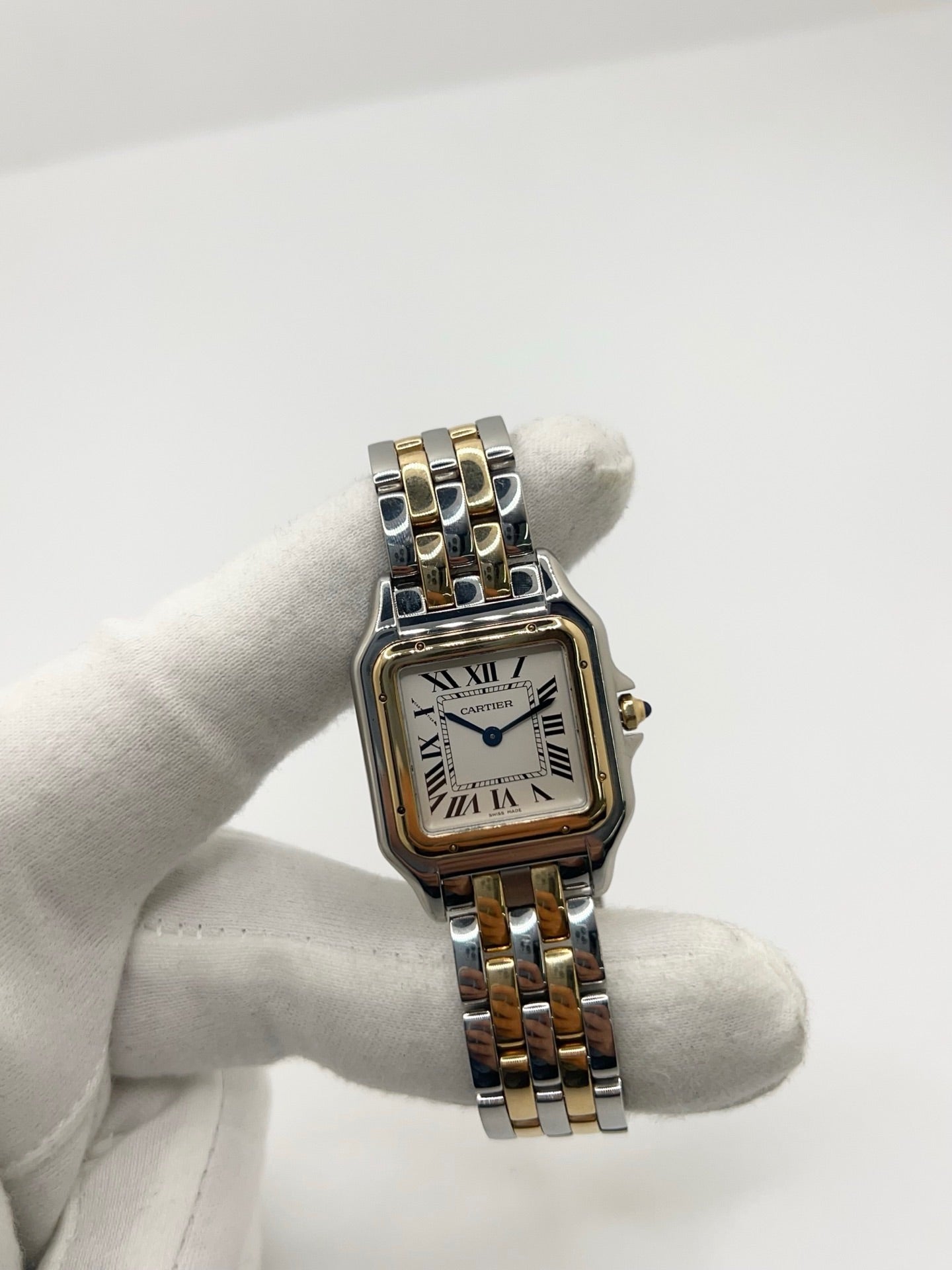 Montre Cartier Panthère W2PN0007 pour femme en acier et or jaune, équipée d’un mouvement quartz. Boîtier de 27 x 37 mm avec verre saphir et cadran argent à chiffres romains, signature élégante de la collection Panthère. Bracelet bicolore en acier et or avec boucle déployante. Étanchéité 3 ATM. Modèle de 2022 en très bon état, avec légères micro-rayures discrètes. Livrée avec coffret et papiers d’origine, idéale comme montre de luxe d’occasion raffinée.
