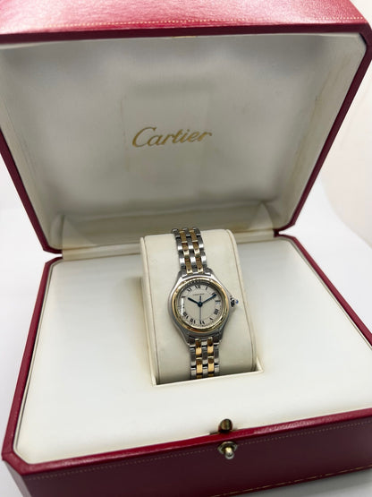 Montre Cartier Panthère référence 119000R pour femme en or jaune et acier, équipée d'un mouvement à quartz. Son boîtier de 26 mm est sublimé par une lunette en or jaune, un cadran blanc à chiffres romains et un verre saphir résistant aux rayures. Son bracelet bicolore en or et acier avec boucle déployante assure un porté confortable. Cette montre d'occasion est en très bon état, révisée en interne et livrée avec son coffret d'origine.