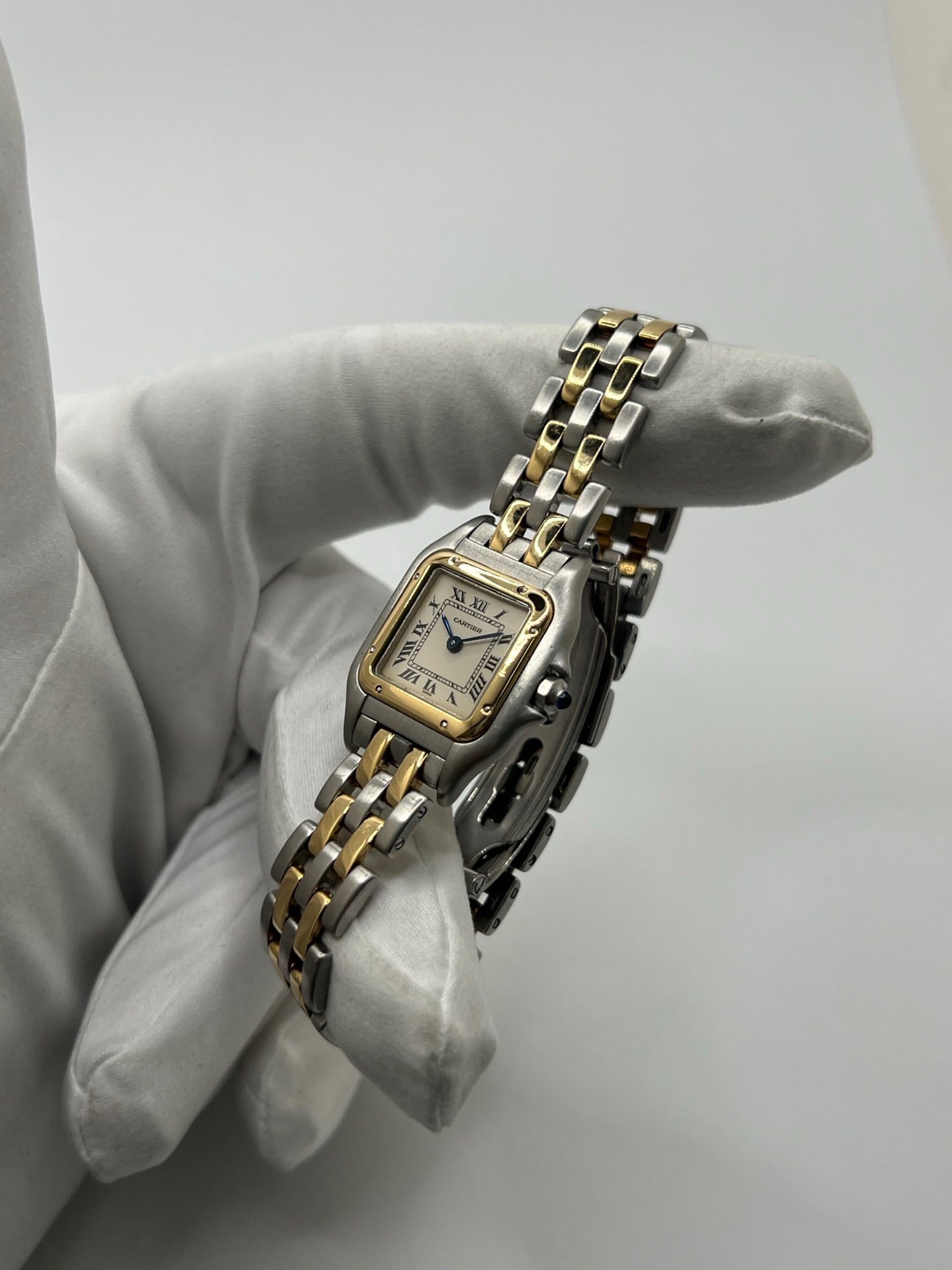 Montre Cartier Panthère 166921 pour femme en or et acier, équipée d’un mouvement quartz suisse. Ce modèle iconique présente un boîtier de 22 x 21 mm, une lunette en or jaune, un cadran blanc à chiffres romains et un verre saphir. Son bracelet en or et acier avec boucle double plis complète son élégance intemporelle. Montre de luxe d’occasion en très bon état, révisée, avec coffret d’origine, idéale pour les amateurs de montres Cartier Panthère femme.