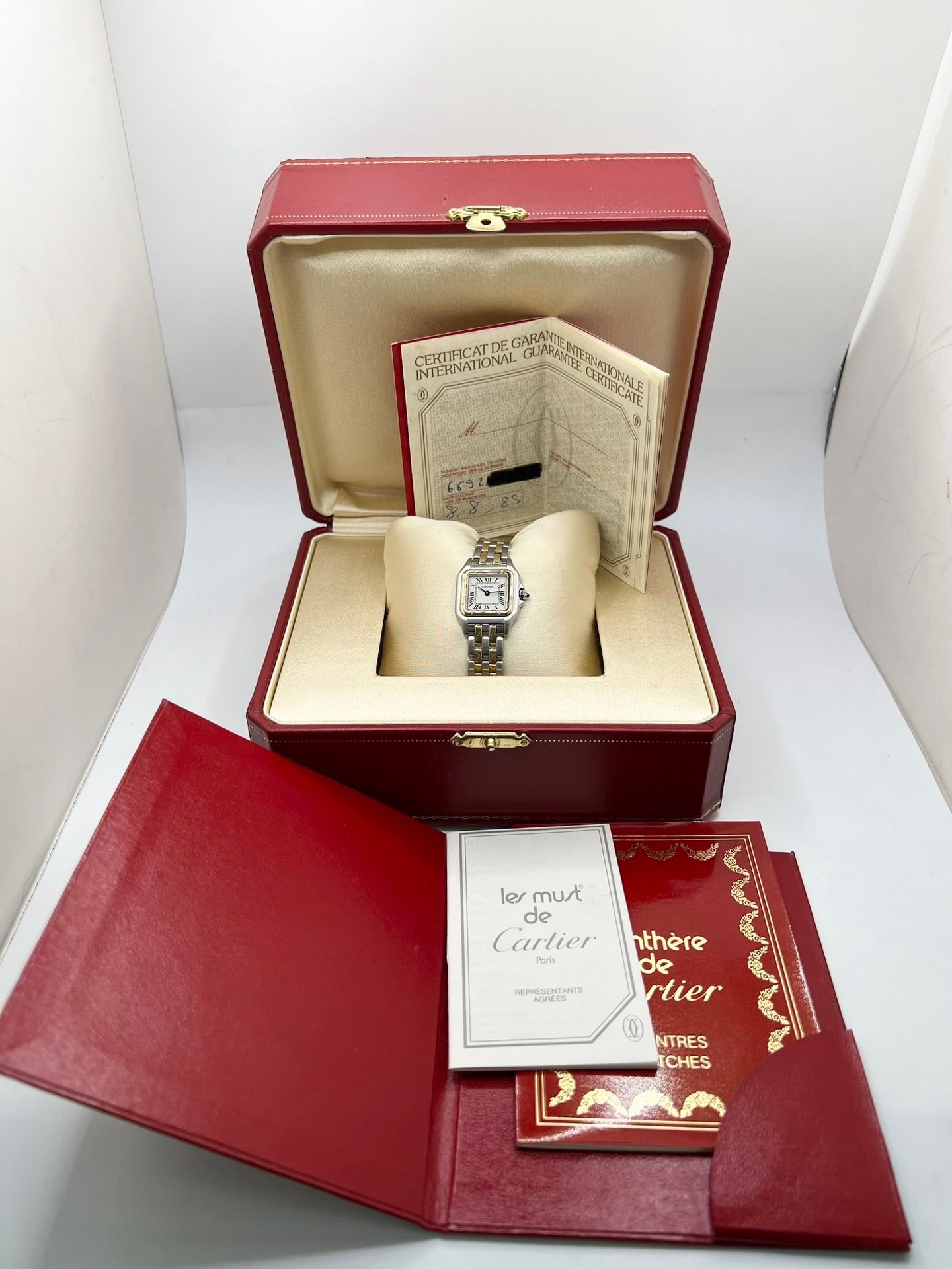 Montre Cartier Panthère référence 66921 pour femme en or jaune et acier, fabriquée en 1985 et équipée d'un mouvement quartz Swiss movement. Son boîtier rectangulaire de 22 x 30 mm est sublimé par une lunette en or jaune, un cadran blanc à chiffres romains et un verre saphir. Cette montre Cartier Panthère bicolore dispose d'un bracelet en or et acier avec boucle déployante. Vendue avec son coffret et ses papiers d'origine, elle est en très bon état et révisée en interne.