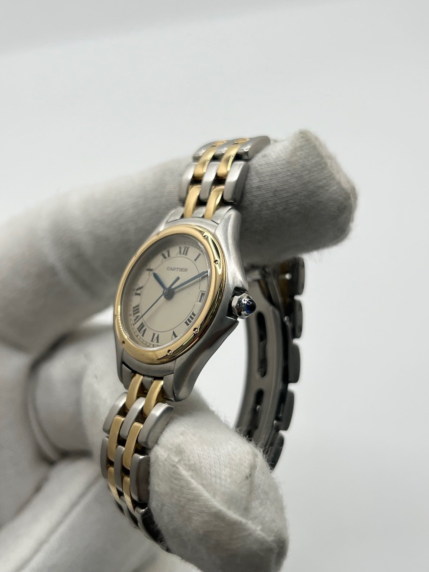 Montre Cartier Panthère référence 119000R pour femme en or jaune et acier, équipée d'un mouvement à quartz. Son boîtier de 26 mm est sublimé par une lunette en or jaune, un cadran blanc à chiffres romains et un verre saphir résistant aux rayures. Son bracelet bicolore en or et acier avec boucle déployante assure un porté confortable. Cette montre d'occasion est en très bon état, révisée en interne et livrée avec son coffret d'origine.