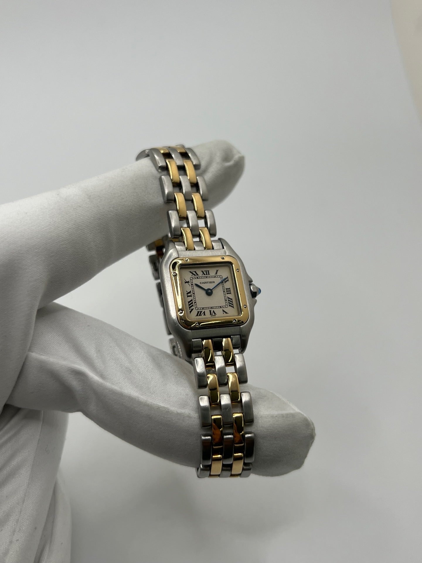 Montre Cartier Panthère 166921 pour femme en or et acier, équipée d’un mouvement quartz suisse. Ce modèle iconique présente un boîtier de 22 x 21 mm, une lunette en or jaune, un cadran blanc à chiffres romains et un verre saphir. Son bracelet en or et acier avec boucle double plis complète son élégance intemporelle. Montre de luxe d’occasion en très bon état, révisée, avec coffret d’origine, idéale pour les amateurs de montres Cartier Panthère femme.