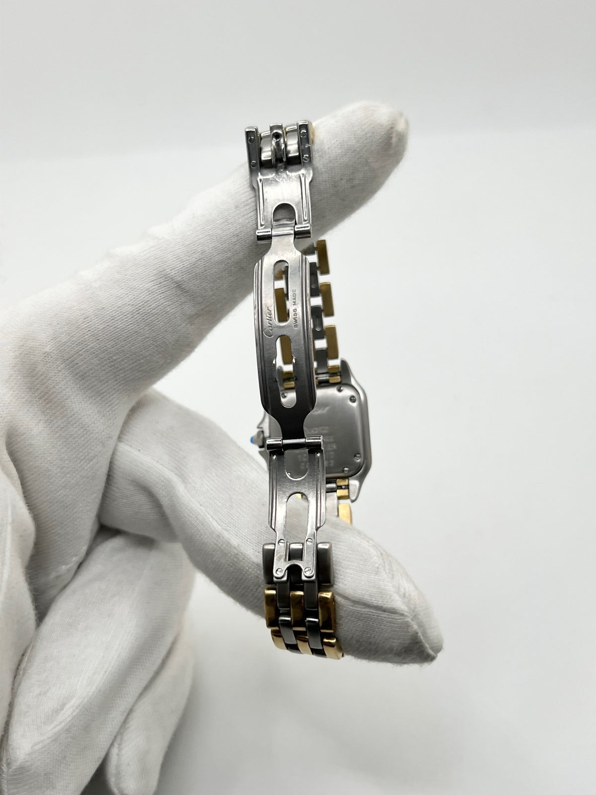 Montre Cartier Panthère 1057917 pour femme, modèle emblématique de la maison Cartier datant de 1989. Cette montre de luxe vintage associe élégamment l’or et l’acier, avec un cadran blanc raffiné, un verre saphir et un mouvement à quartz. La Cartier Panthère référence 1057917 est proposée d’occasion en très bon état, avec son coffret et ses papiers d’origine. Révisée en interne le 19 octobre 2026, cette montre Cartier Panthère en or et acier allie élégance intemporelle et savoir-faire horloger.