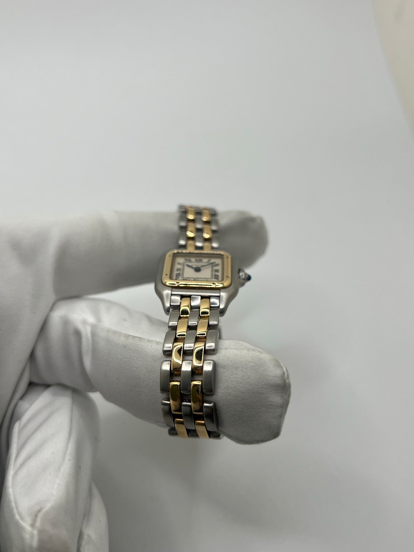 Montre Cartier Panthère 166921 pour femme en or et acier, équipée d’un mouvement quartz suisse. Ce modèle iconique présente un boîtier de 22 x 21 mm, une lunette en or jaune, un cadran blanc à chiffres romains et un verre saphir. Son bracelet en or et acier avec boucle double plis complète son élégance intemporelle. Montre de luxe d’occasion en très bon état, révisée, avec coffret d’origine, idéale pour les amateurs de montres Cartier Panthère femme.