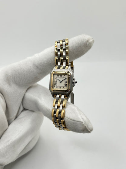 Montre Cartier Panthère 1057917 pour femme, modèle emblématique de la maison Cartier datant de 1989. Cette montre de luxe vintage associe élégamment l’or et l’acier, avec un cadran blanc raffiné, un verre saphir et un mouvement à quartz. La Cartier Panthère référence 1057917 est proposée d’occasion en très bon état, avec son coffret et ses papiers d’origine. Révisée en interne le 19 octobre 2026, cette montre Cartier Panthère en or et acier allie élégance intemporelle et savoir-faire horloger.
