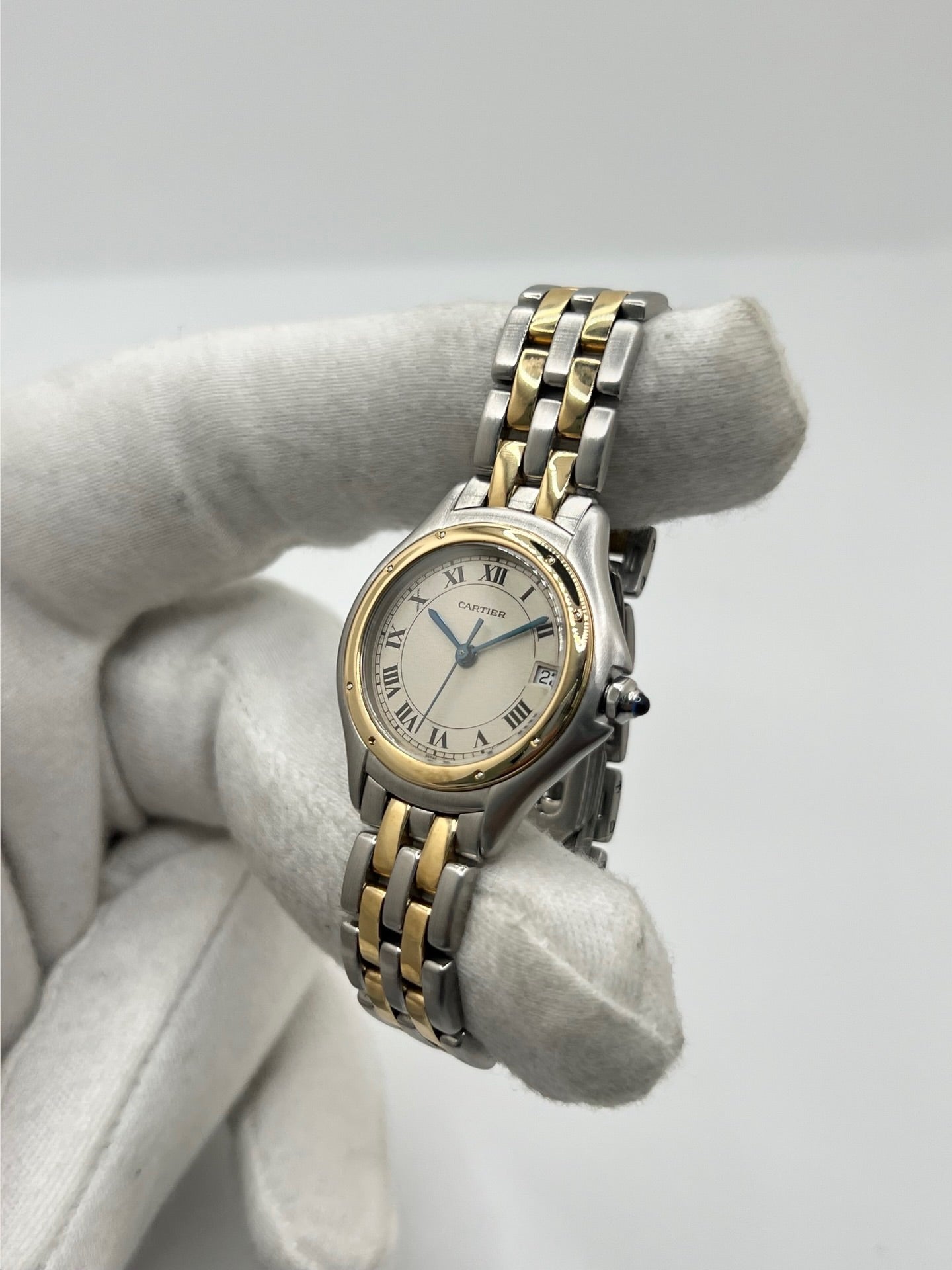 Montre Cartier Panthère référence 119000R pour femme en or jaune et acier, équipée d'un mouvement à quartz. Son boîtier de 26 mm est sublimé par une lunette en or jaune, un cadran blanc à chiffres romains et un verre saphir résistant aux rayures. Son bracelet bicolore en or et acier avec boucle déployante assure un porté confortable. Cette montre d'occasion est en très bon état, révisée en interne et livrée avec son coffret d'origine.