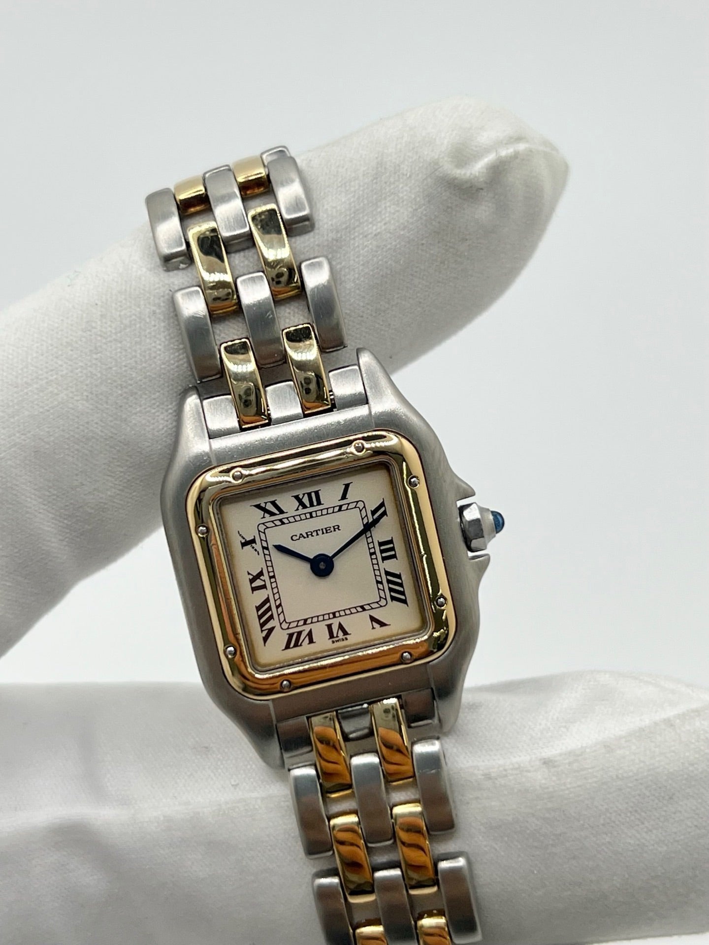 Montre Cartier Panthère 166921 pour femme en or et acier, équipée d’un mouvement quartz suisse. Ce modèle iconique présente un boîtier de 22 x 21 mm, une lunette en or jaune, un cadran blanc à chiffres romains et un verre saphir. Son bracelet en or et acier avec boucle double plis complète son élégance intemporelle. Montre de luxe d’occasion en très bon état, révisée, avec coffret d’origine, idéale pour les amateurs de montres Cartier Panthère femme.