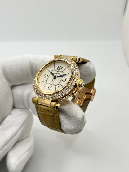 Montre Cartier Pasha 820901 en or jaune, équipée d’un mouvement automatique et d’un boîtier de 38 mm. Son cadran blanc est protégé par un verre saphir et son boîtier offre une étanchéité jusqu’à 10 ATM. Cette montre Cartier Pasha est montée sur un bracelet beige en cuir de crocodile avec boucle déployante en or rose. Dotée d’un affichage de la date, elle associe élégance, caractère et raffinement. Un modèle iconique en très bon état.