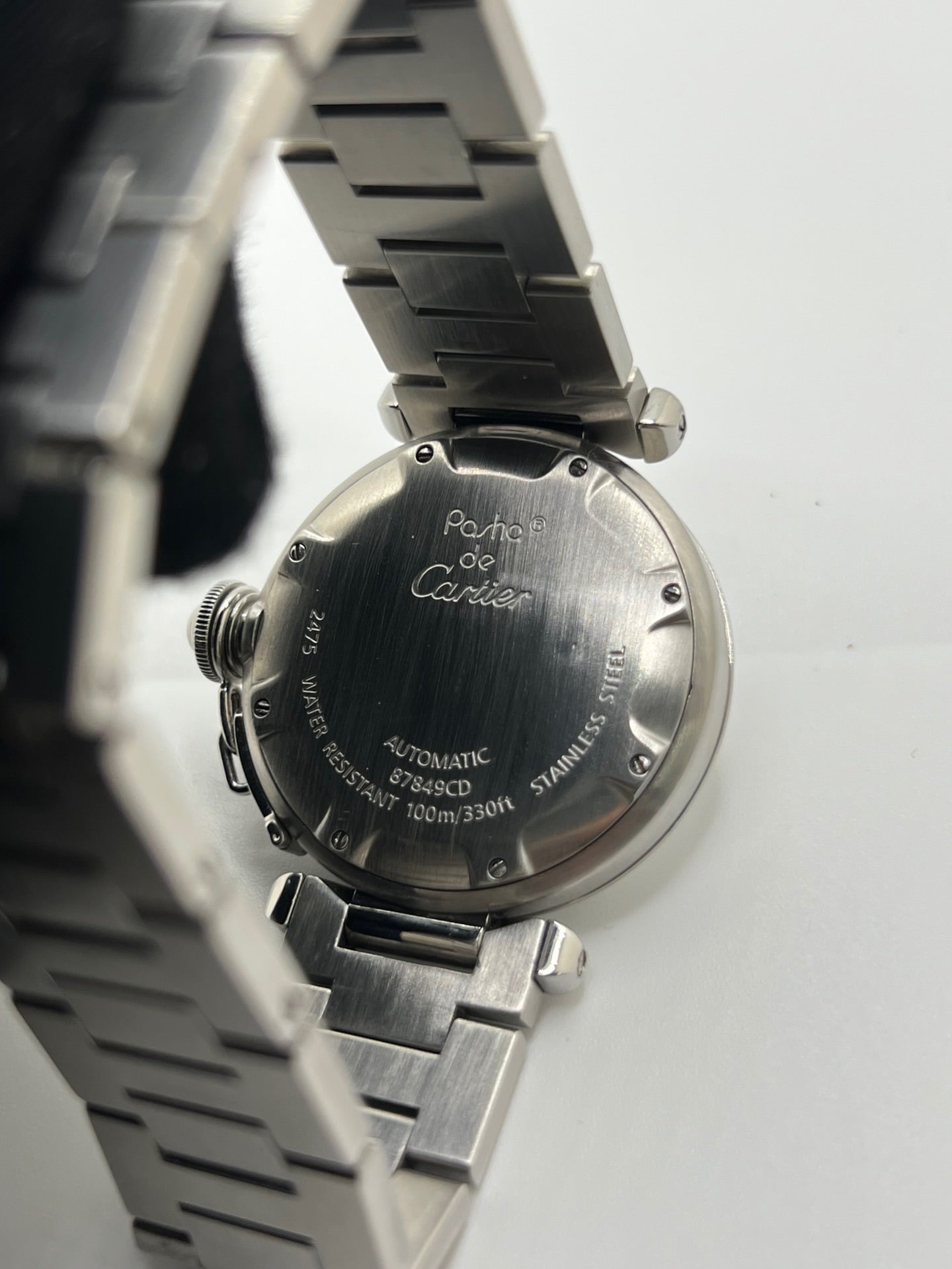 Montre de luxe Cartier Pasha C référence 2475 en acier, équipée d’un mouvement automatique calibre 052. Son boîtier de 35 mm et son cadran blanc à chiffres arabes offrent un style élégant et intemporel. Avec verre saphir, étanchéité 10 ATM et bracelet en acier, cette Pasha C combine performance, précision et raffinement.