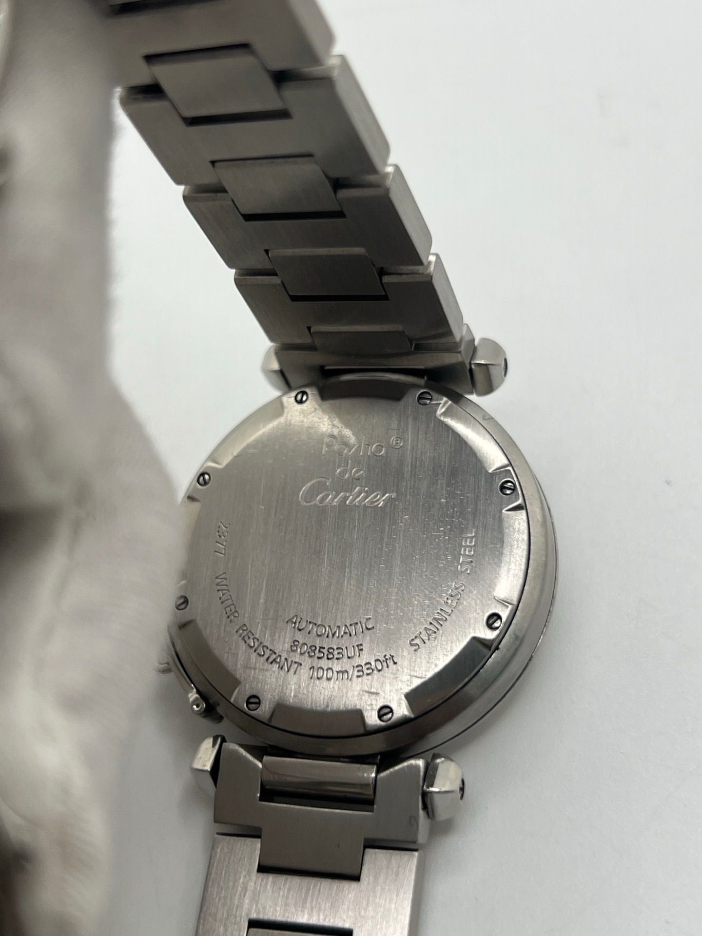 Montre Cartier Pasha C GMT réf. 2377 en acier, dotée d’un mouvement automatique calibre 048. Son boîtier de 35 mm abrite un cadran argenté à chiffres arabes, protégé par un verre saphir. Étanche jusqu’à 10 ATM, cette montre élégante et fonctionnelle est équipée d’un bracelet en acier et d’une boucle déployante double plis.