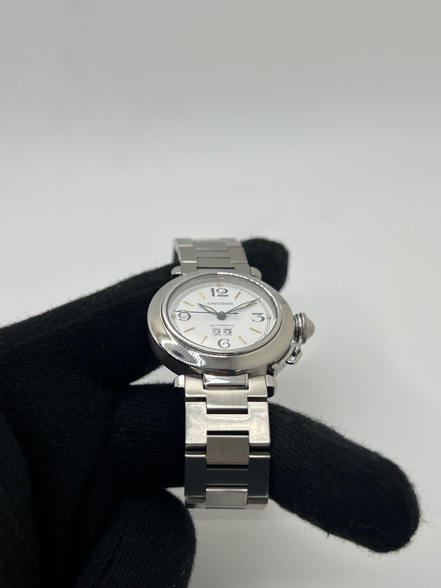 Montre de luxe Cartier Pasha C référence 2475 en acier, équipée d’un mouvement automatique calibre 052. Son boîtier de 35 mm et son cadran blanc à chiffres arabes offrent un style élégant et intemporel. Avec verre saphir, étanchéité 10 ATM et bracelet en acier, cette Pasha C combine performance, précision et raffinement.