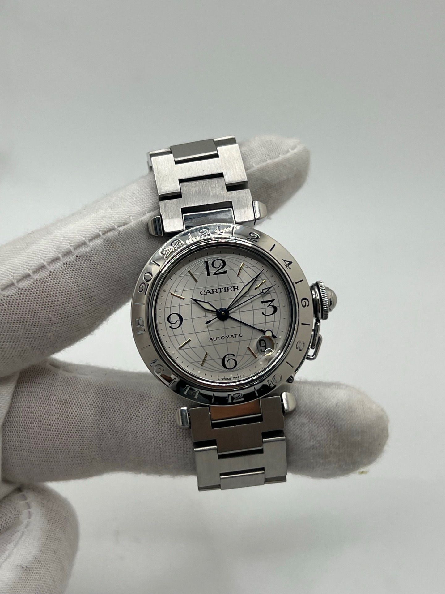 Montre Cartier Pasha C GMT réf. 2377 en acier, dotée d’un mouvement automatique calibre 048. Son boîtier de 35 mm abrite un cadran argenté à chiffres arabes, protégé par un verre saphir. Étanche jusqu’à 10 ATM, cette montre élégante et fonctionnelle est équipée d’un bracelet en acier et d’une boucle déployante double plis.