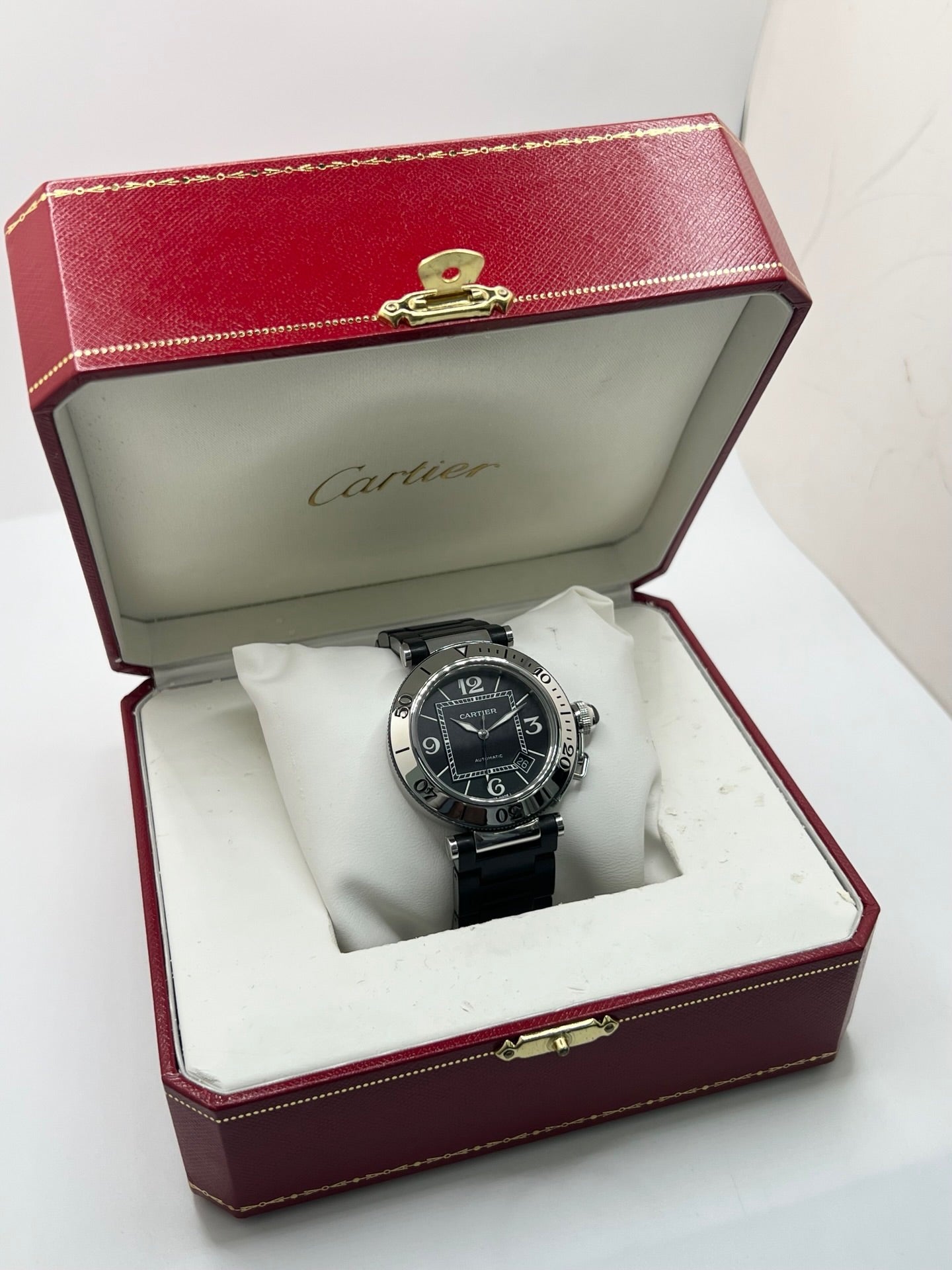 Montre Cartier Pasha Seatimer référence 2790 en acier inoxydable avec boîtier de 40 mm, mouvement automatique calibre 049 basé sur l'ETA 2892-A2 et réserve de marche de 42 heures. Son cadran noir à chiffres arabes est protégé par un verre saphir. Équipée d'un bracelet en acier avec boucle déployante, cette montre est étanche à 10 ATM et dispose d'un guichet date. Vendue avec son coffret et ses papiers d'origine, révisée en interne et en très bon état.